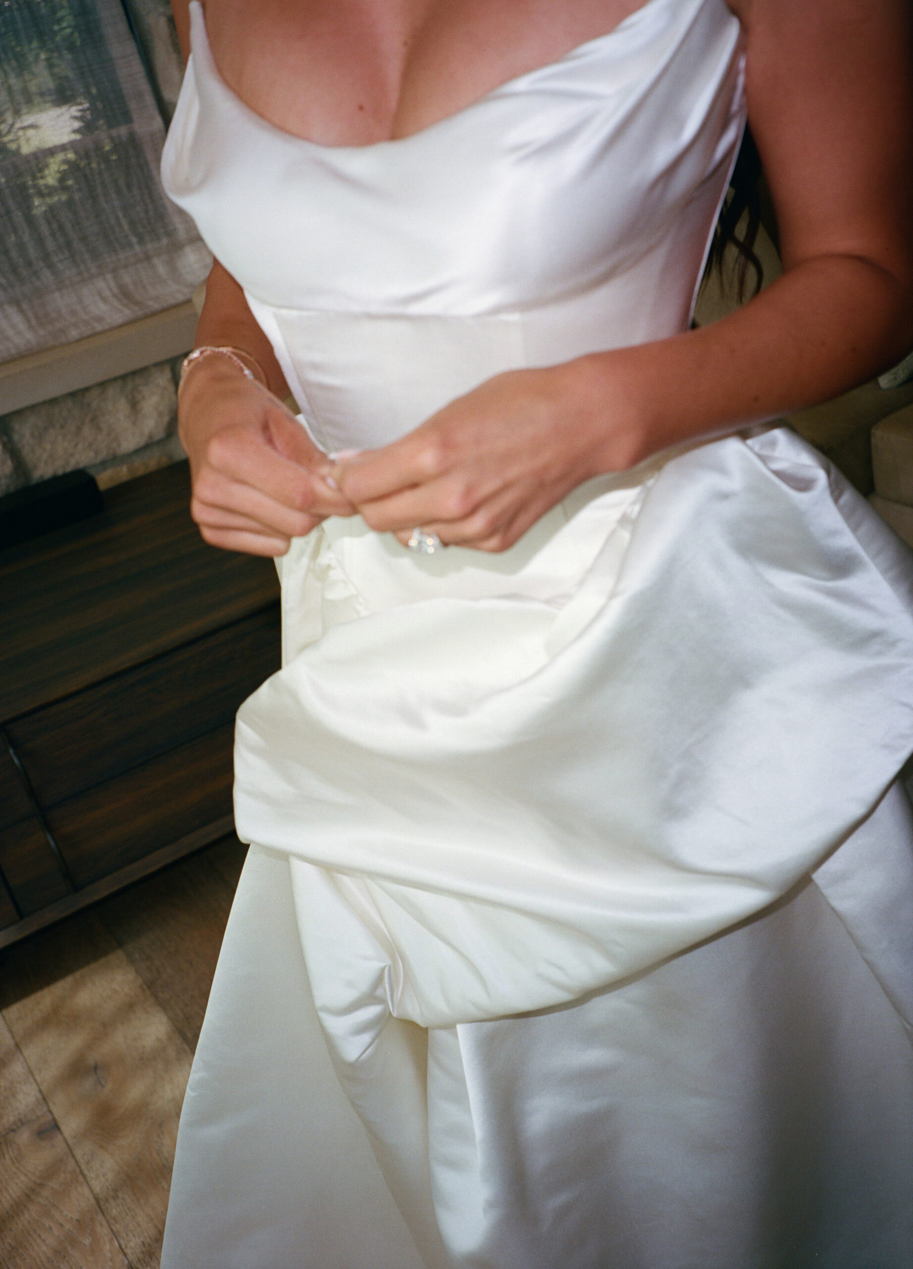 Up close film photo of the bride's satin wedding dress with a corset and cat eye neckline