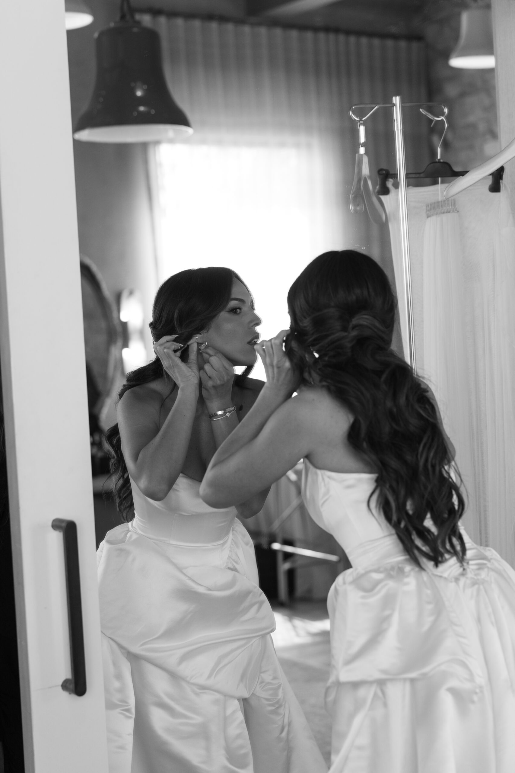 Bride putting on her earrings before her wedding ceremony