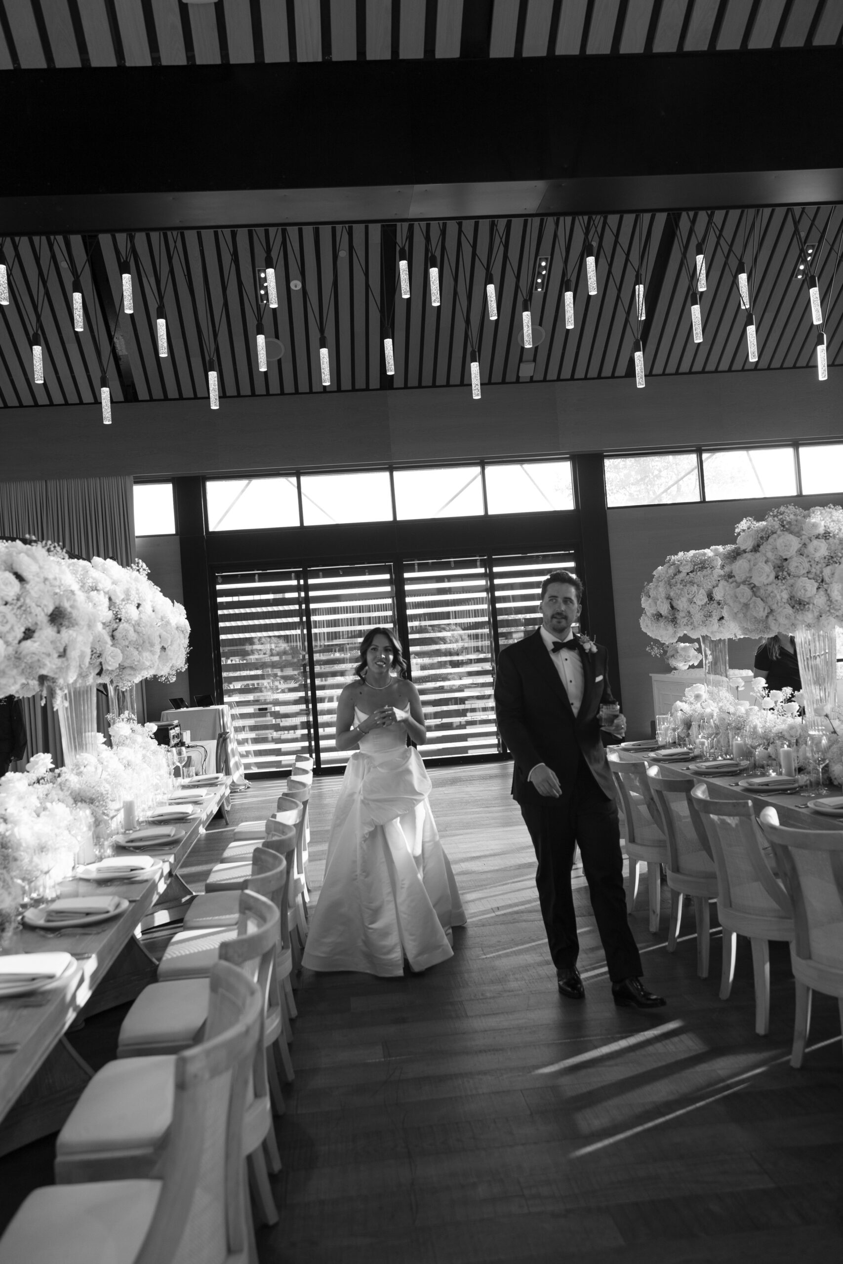Black and white photo of bride and groom seeing their wedding reception setup