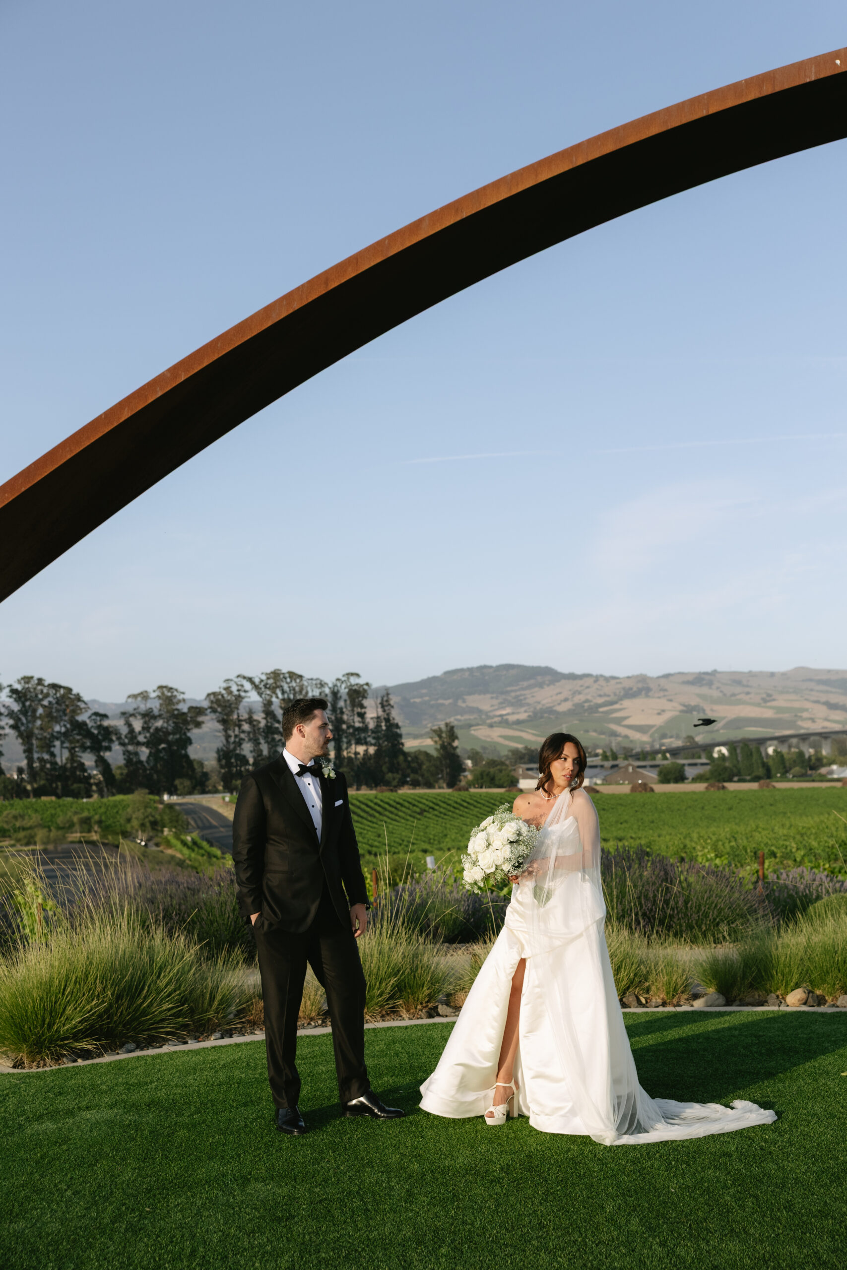 Bride and groom posing for editorial wedding photos in front of the lavender lawn