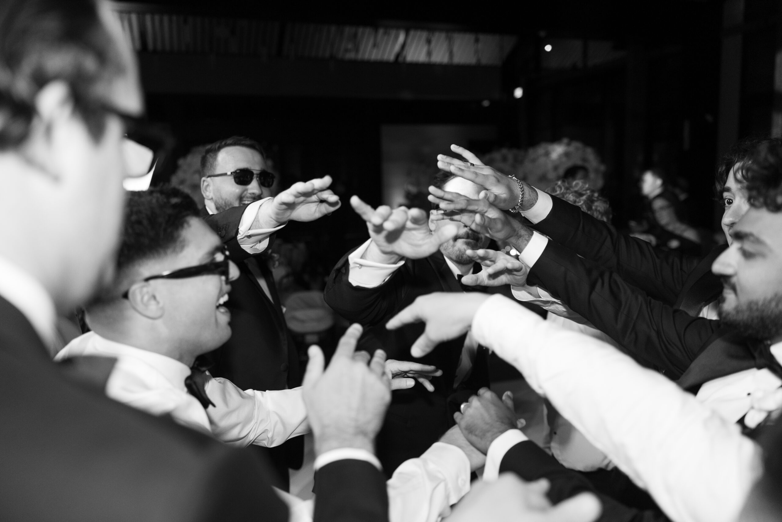 A candid wedding photo of groomsmen dancing at the wedding reception