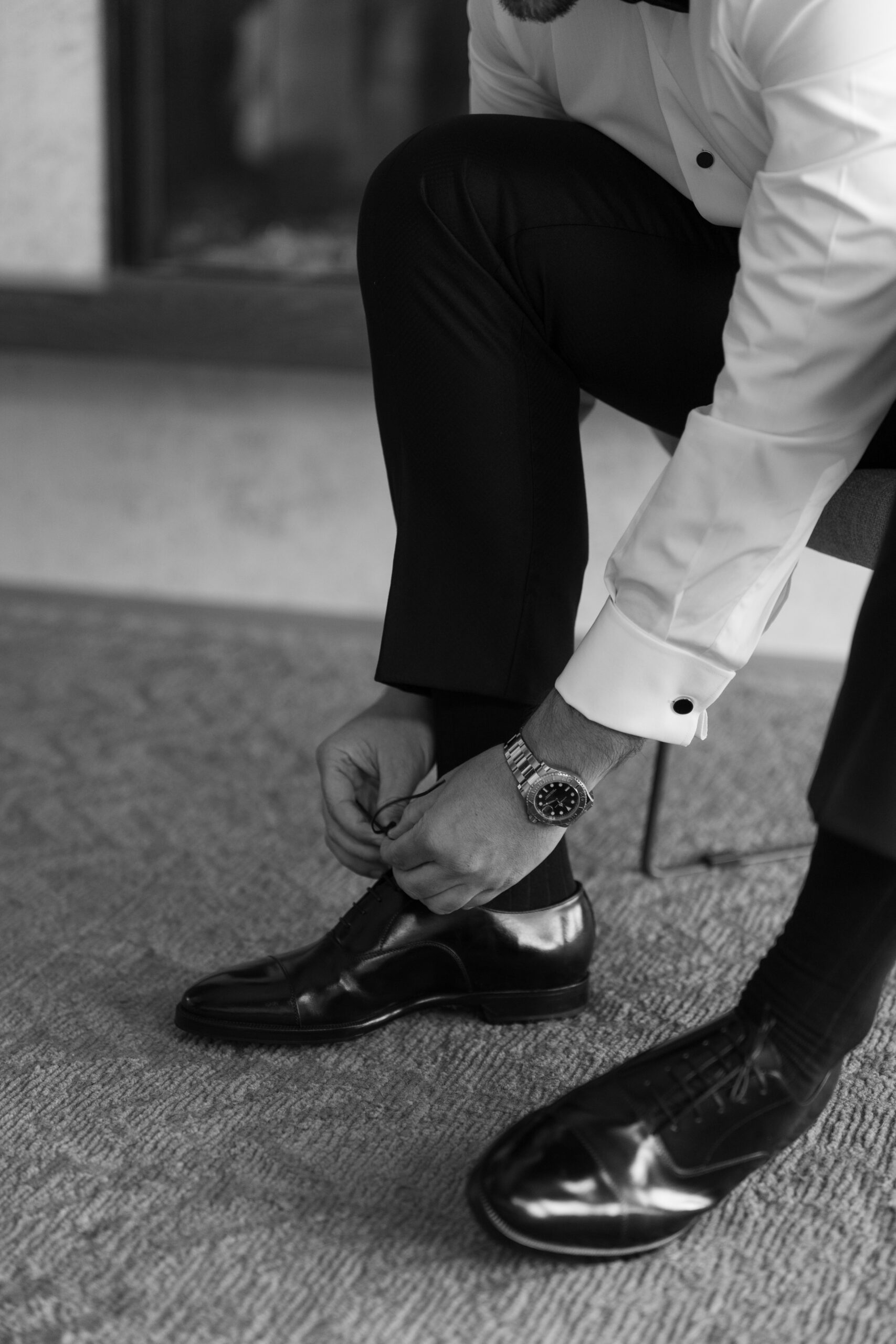 Groom getting ready photo, tying his shoes