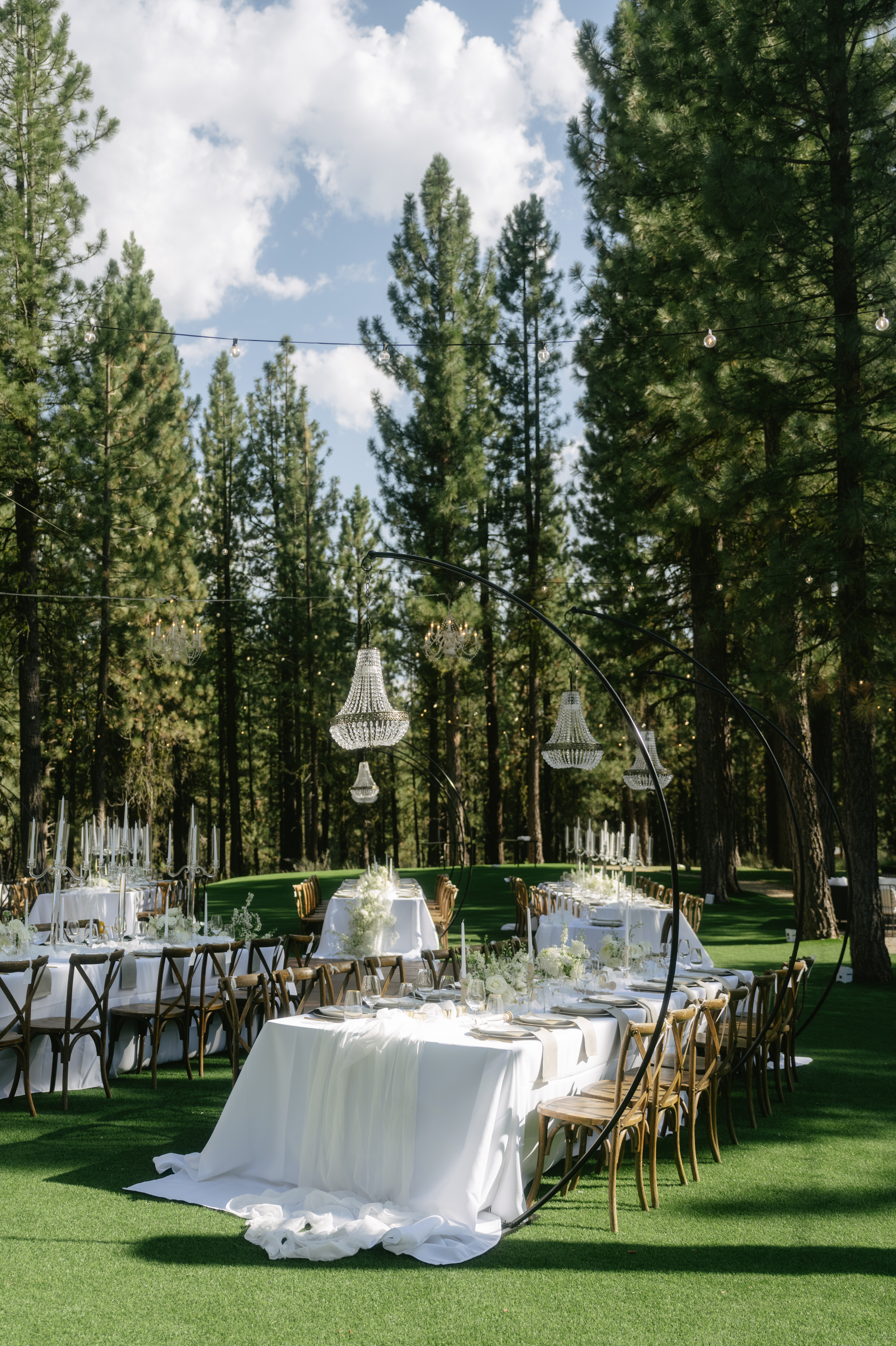 Wedding reception setup with 2026 wedding trends of chandeliers, monochrome flowers, and an outdoor wedding reception