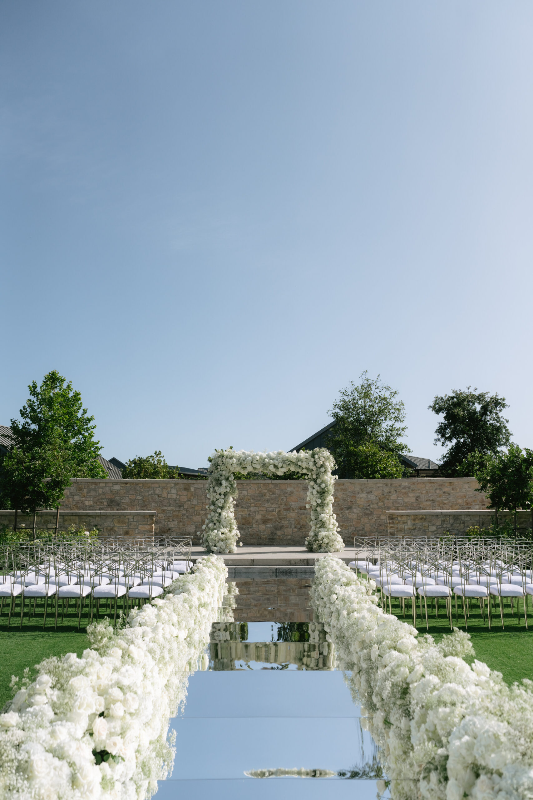 White wedding decor with a mirror aisle