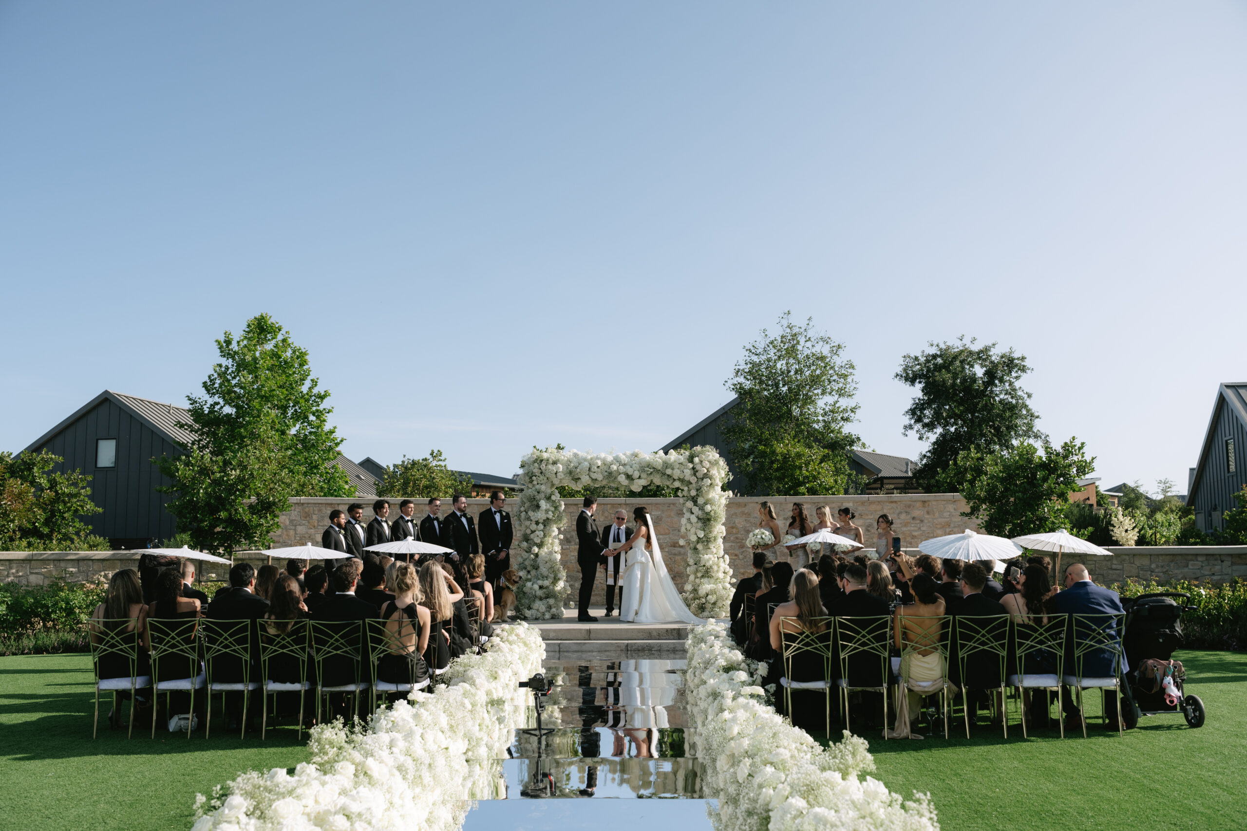 A wedding ceremony at Stanly Ranch with a mirror wedding aisle and white florals