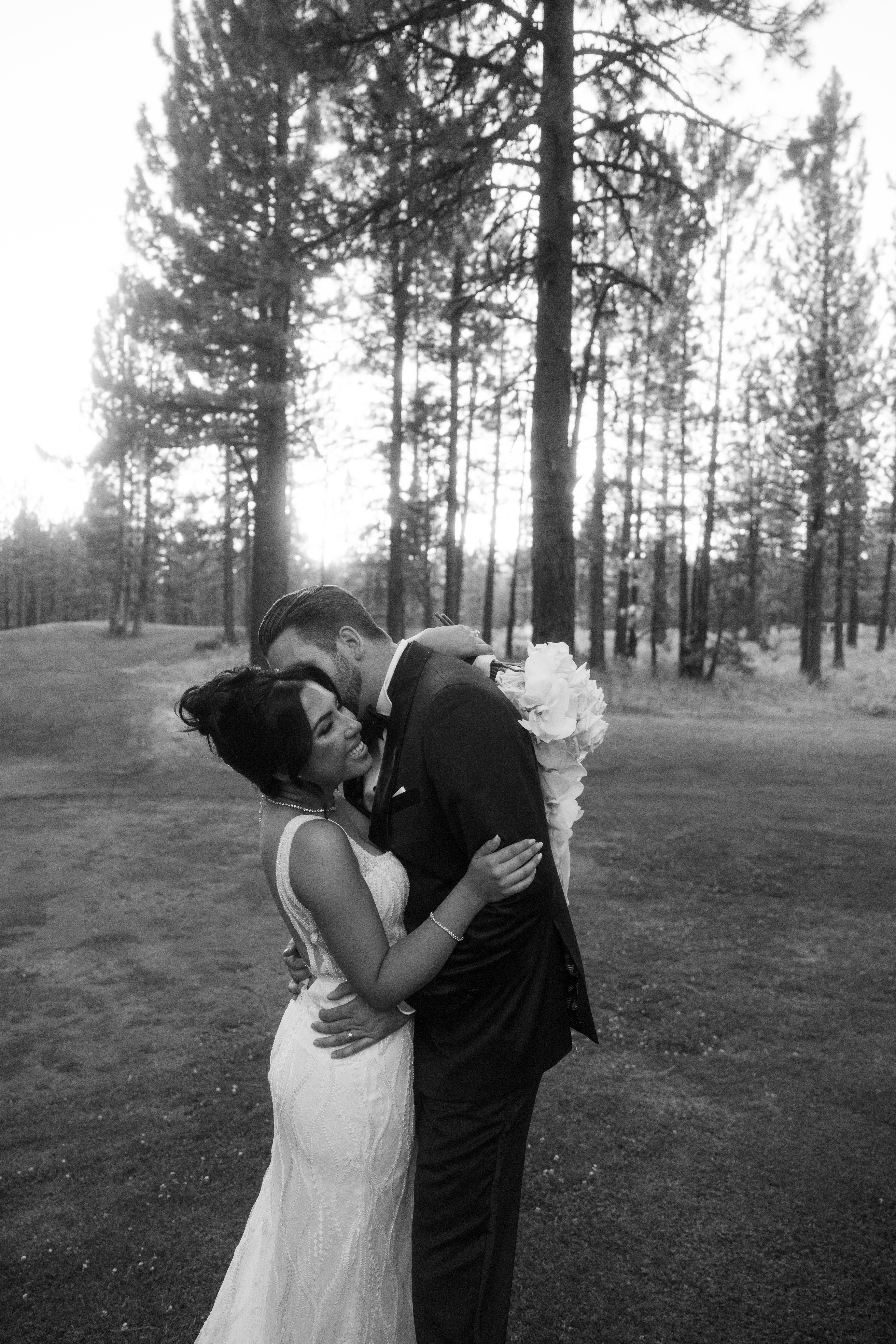 Groom kissing bride on the cheek in black and white wedding photo