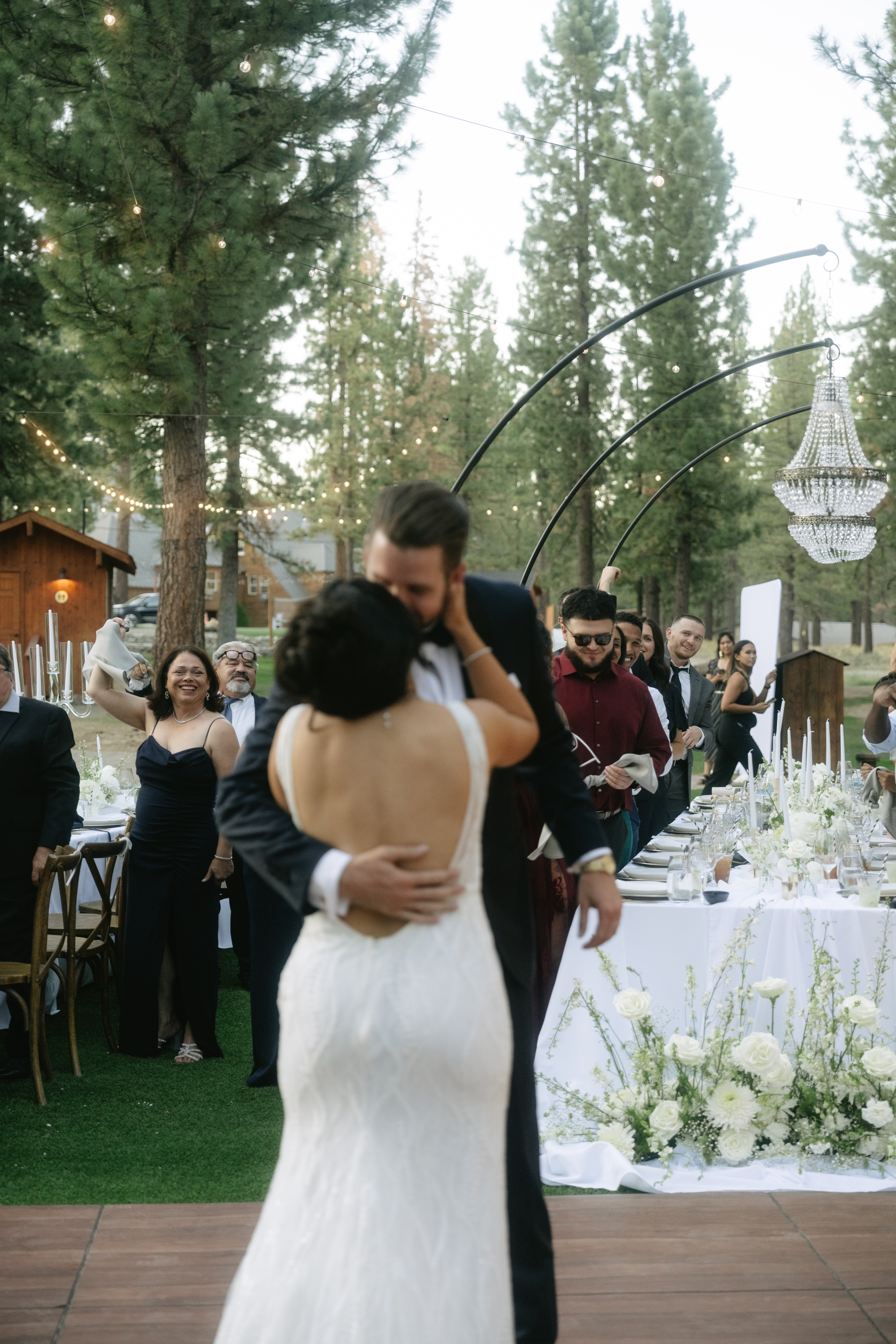 Bride and groom kissing at wedding reception in a candid photo