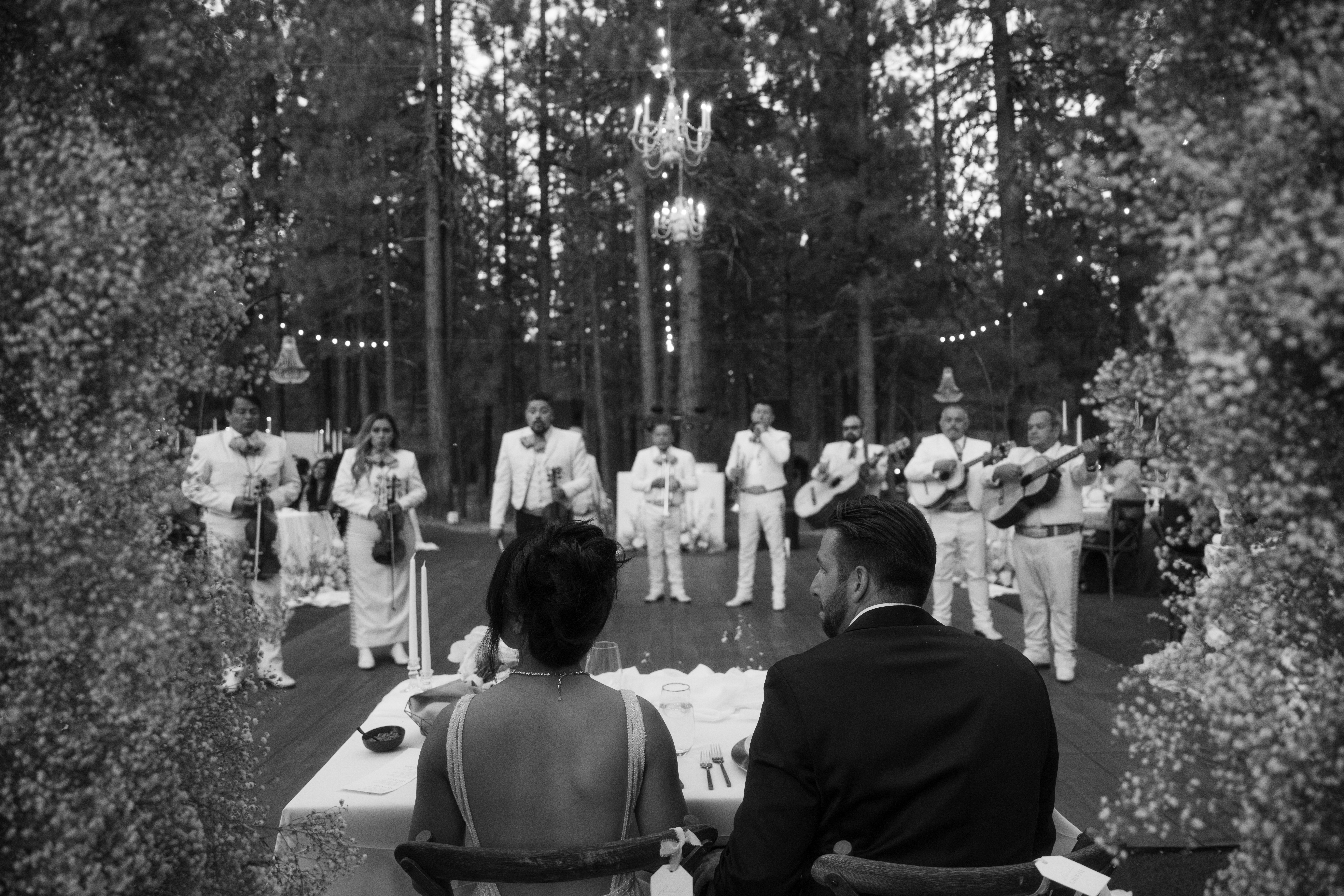Black and white candid wedding photo of bride and groom watching their live band perform