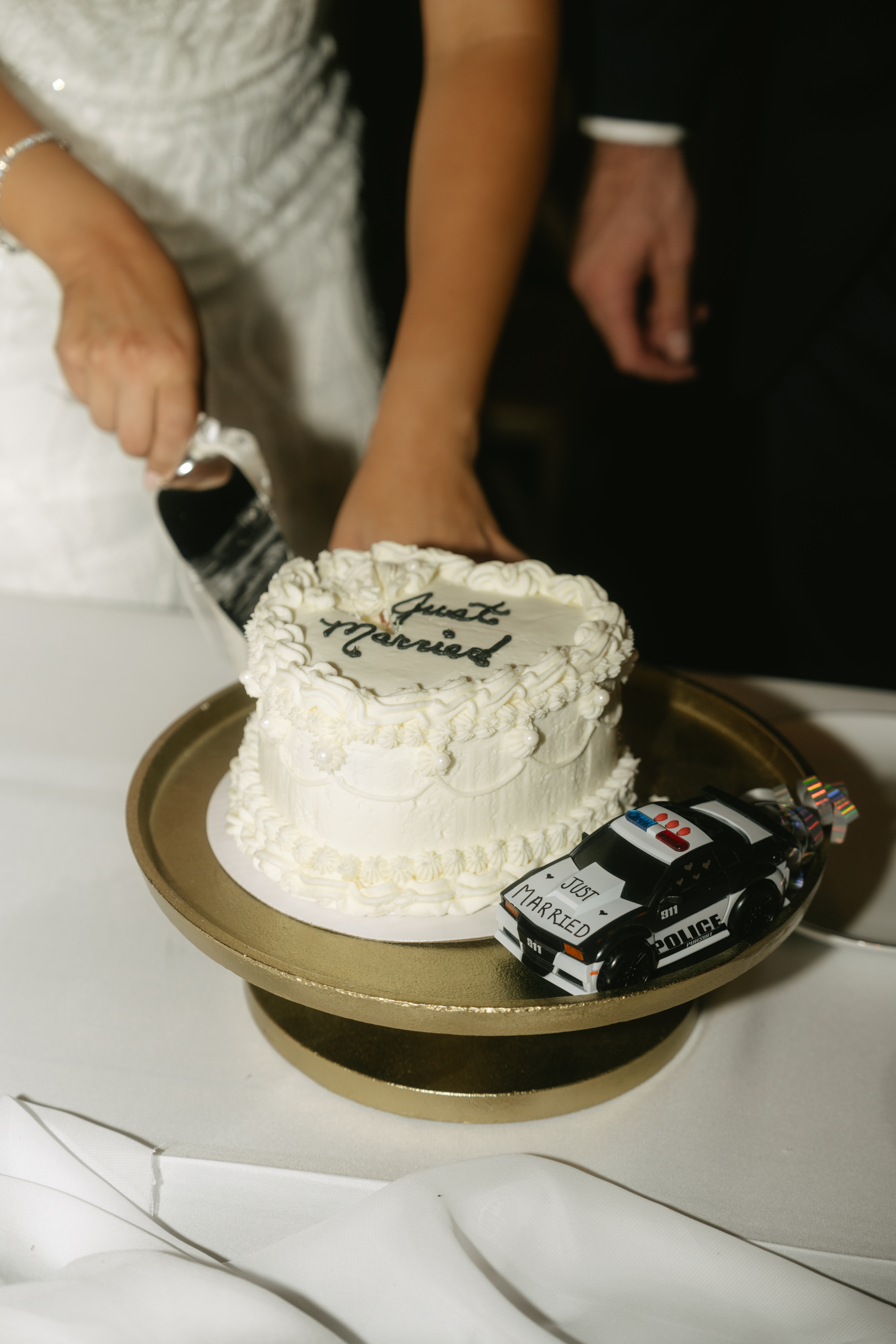 Vintage wedding cake reading "just married" with a cop car beside it