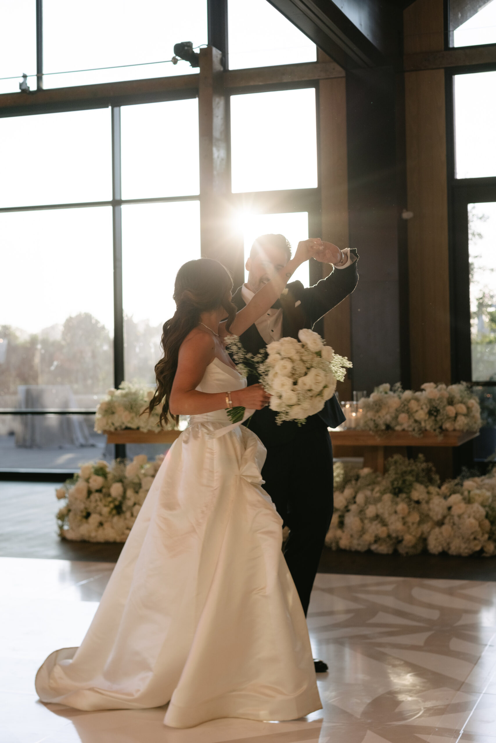 Bride and groom dancing in the Glasshouse Barn with the light hitting in the windows