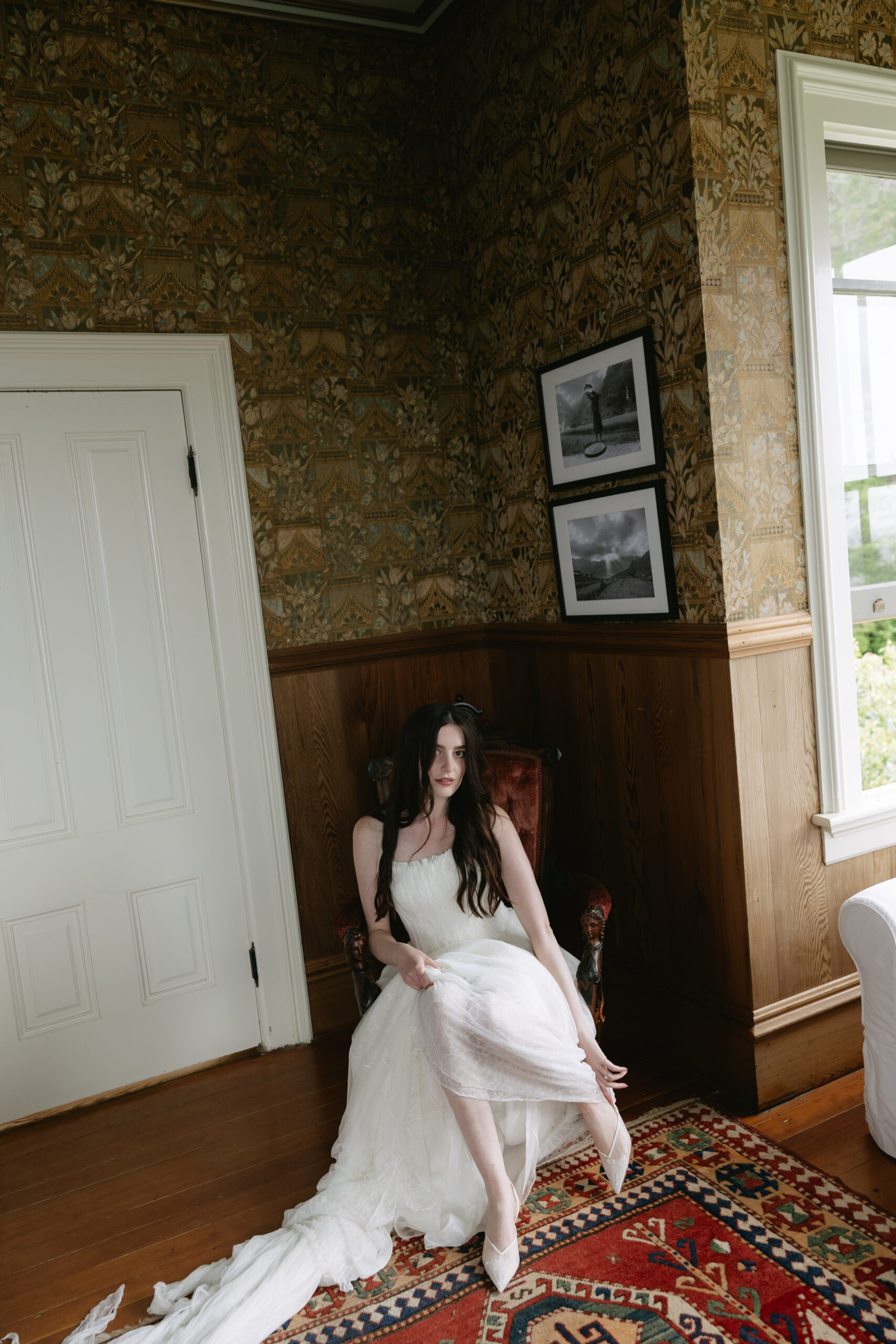 Bride putting her shoes on in a historic room at Switzer Farm