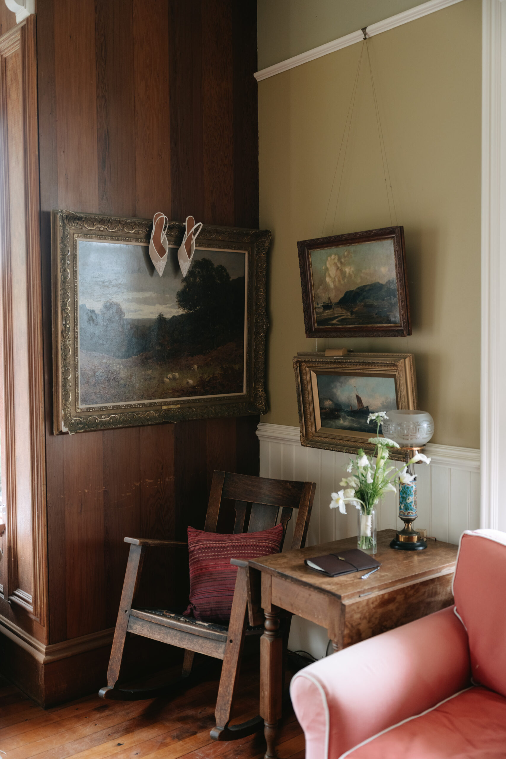 A bride's wedding shoes hanging on a picture frame in a historic home