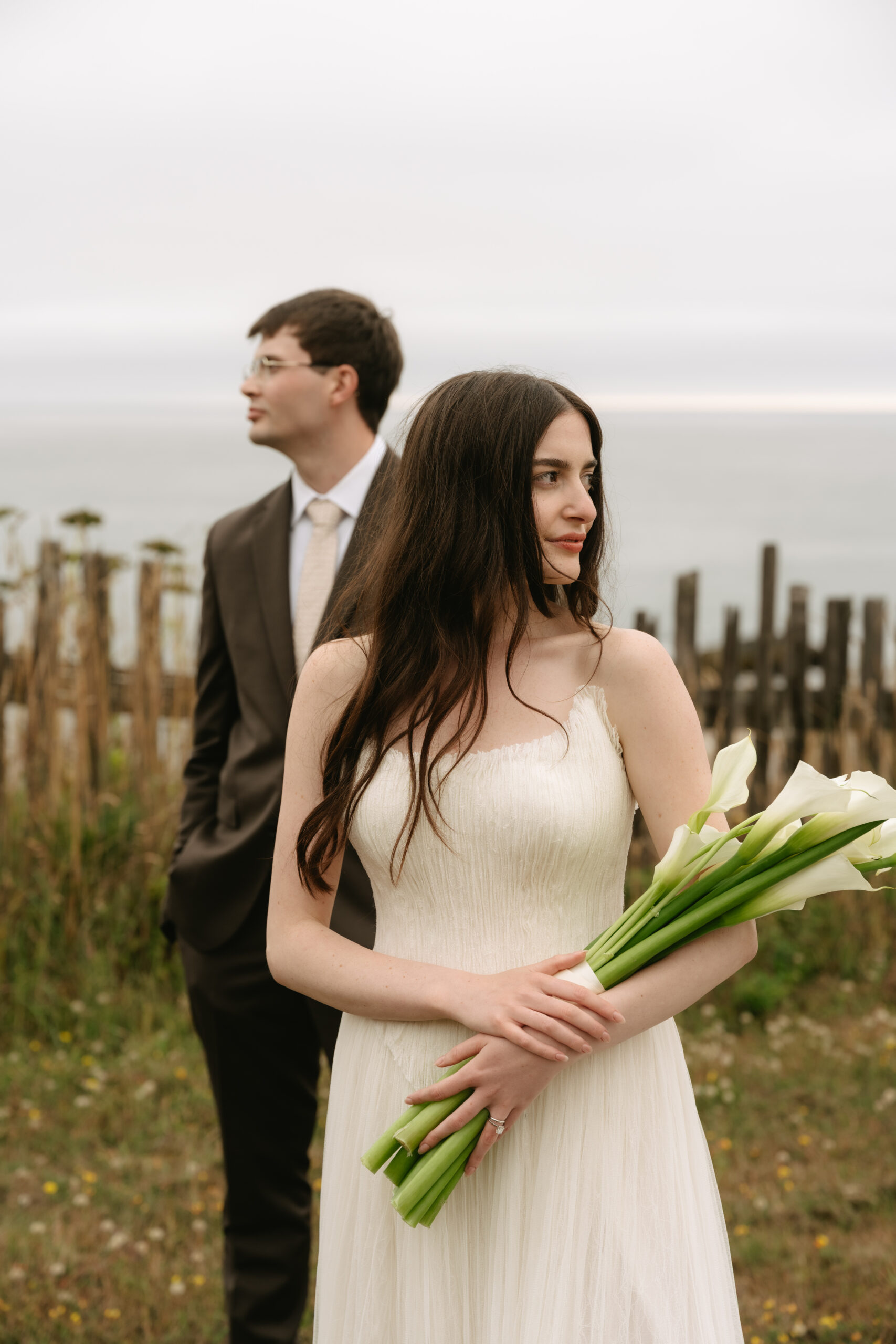 Bride and groom posing for wedding photos looking opposite directions