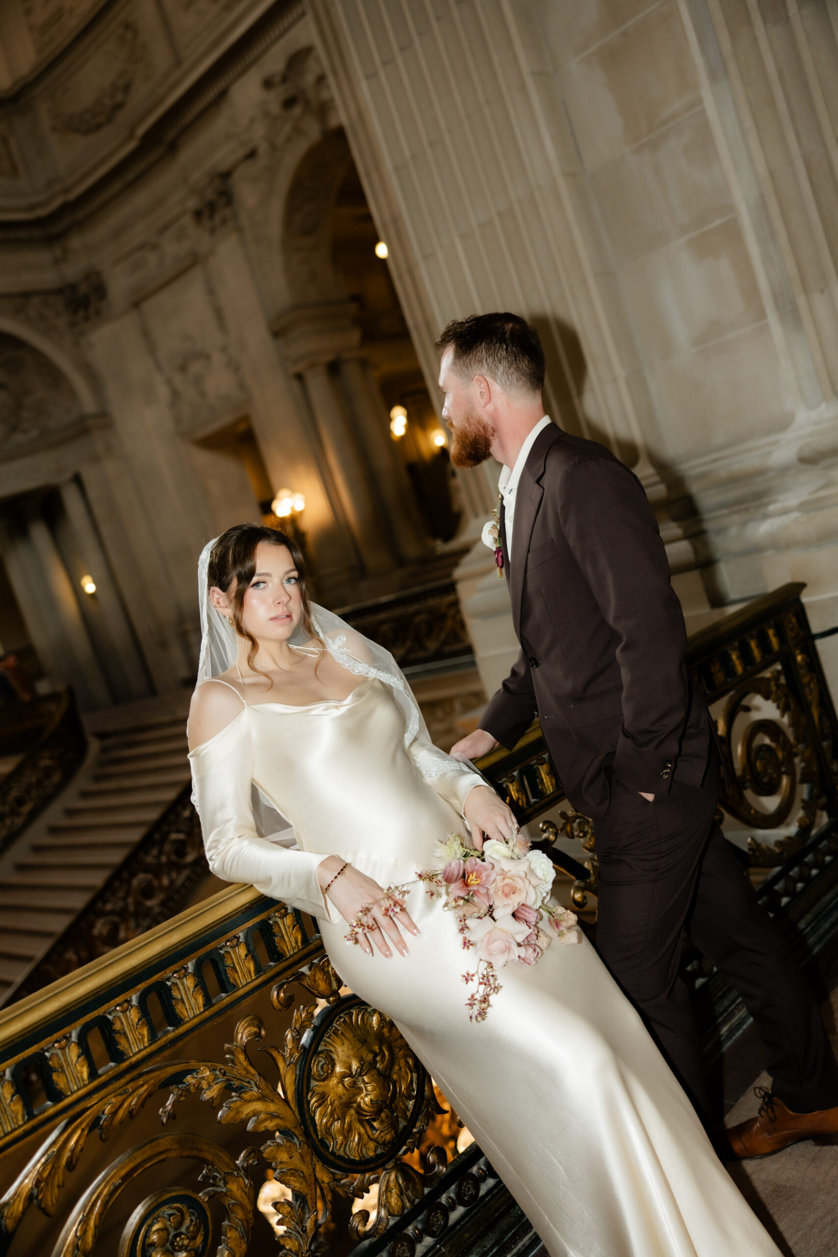 A bride leaning against the railing at San Francisco City Hall