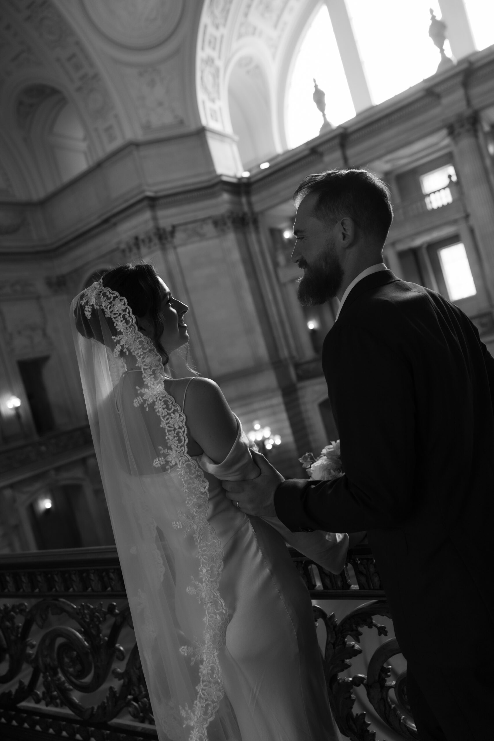 A black and white editorial wedding photo of bride and groom in San Francisco City Hall