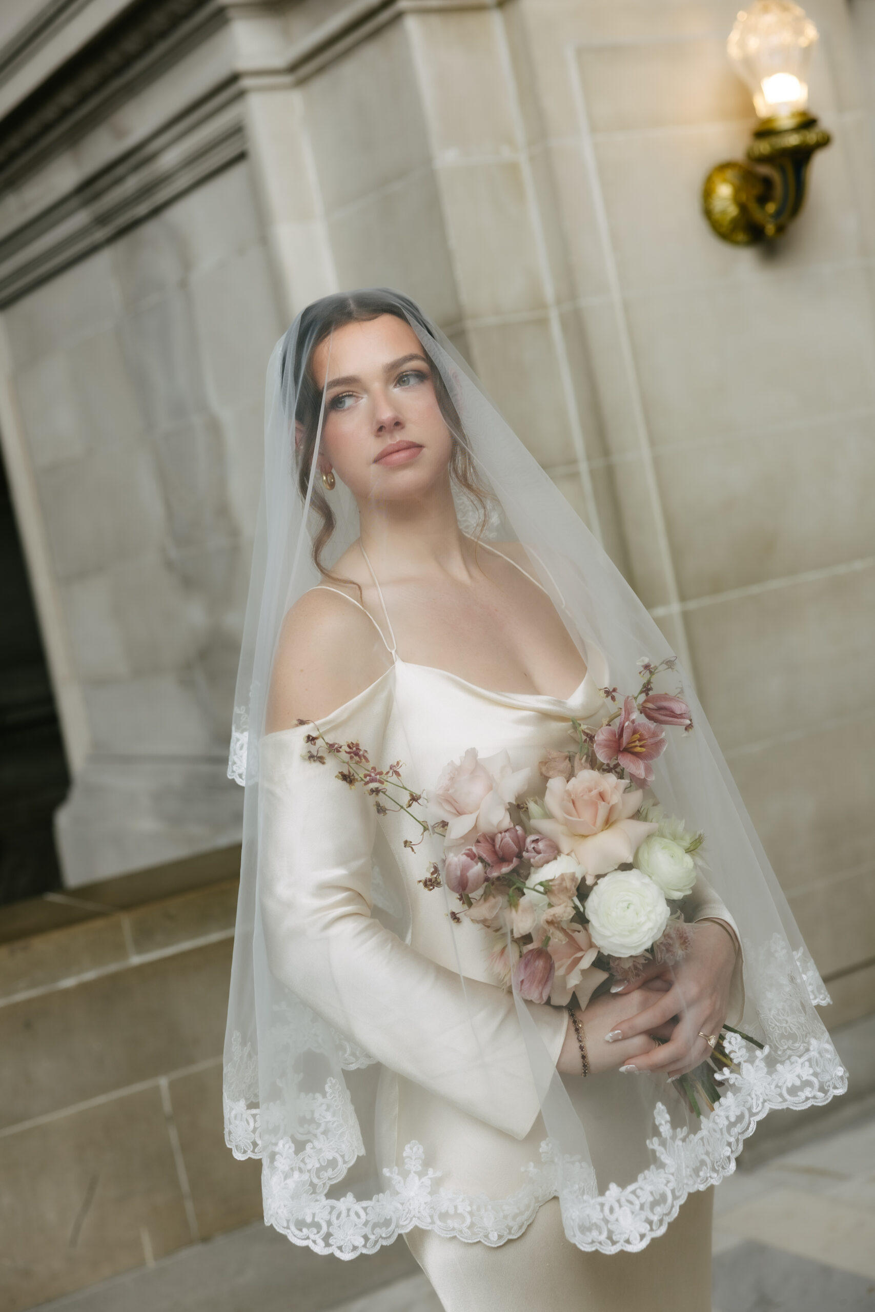 A bride under a lace trim veil for a bridal portrait