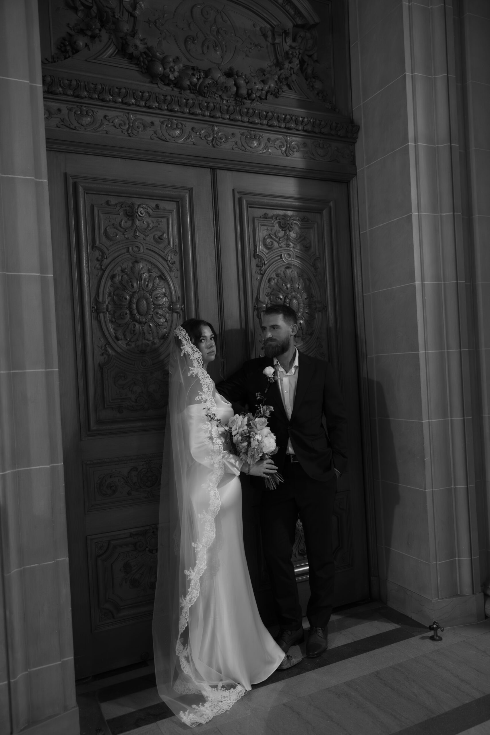 A couple posing in a black and white wedding photo at SF city hall