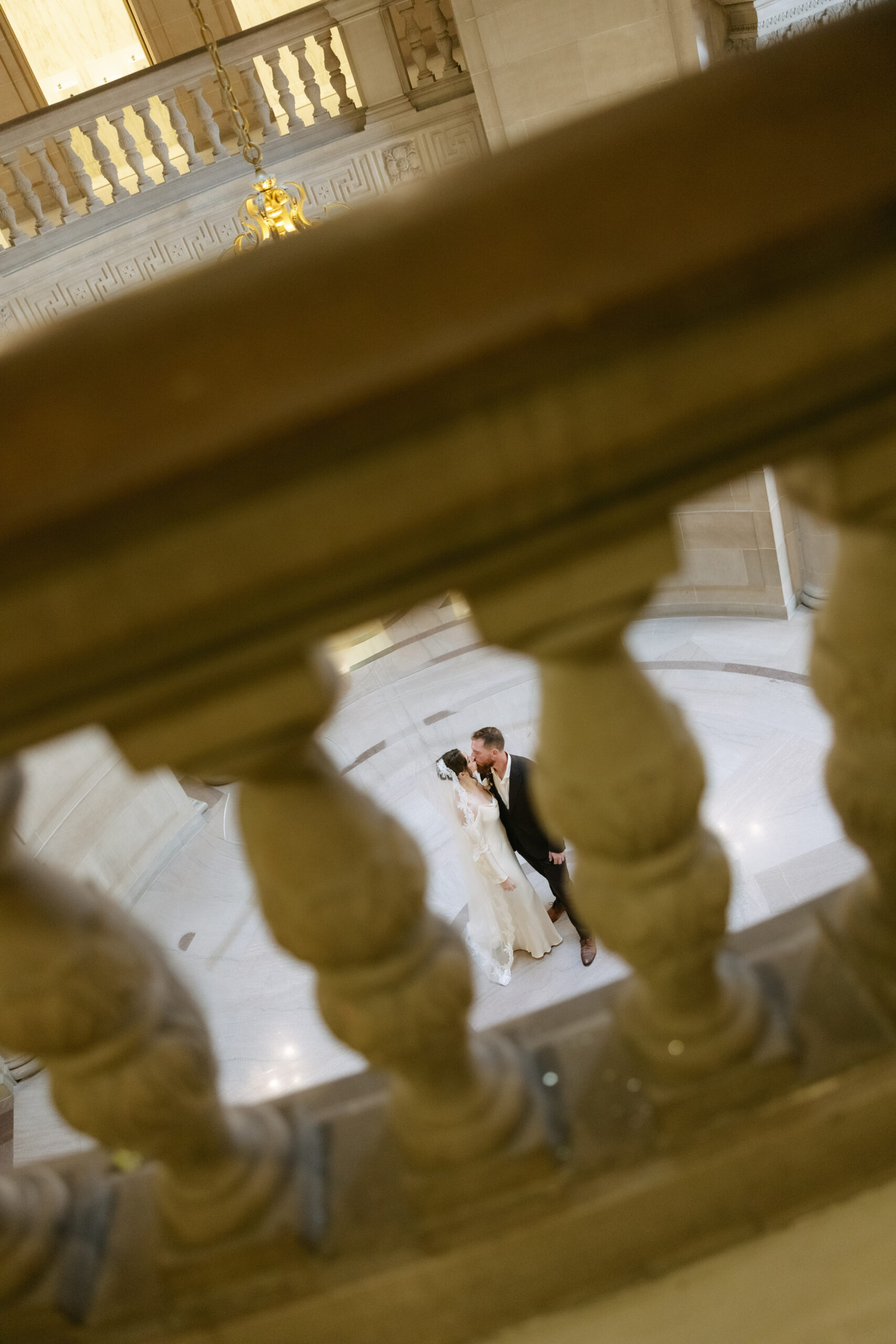 A photo of a bride and groom kissing taken from above at San Francisco city hall