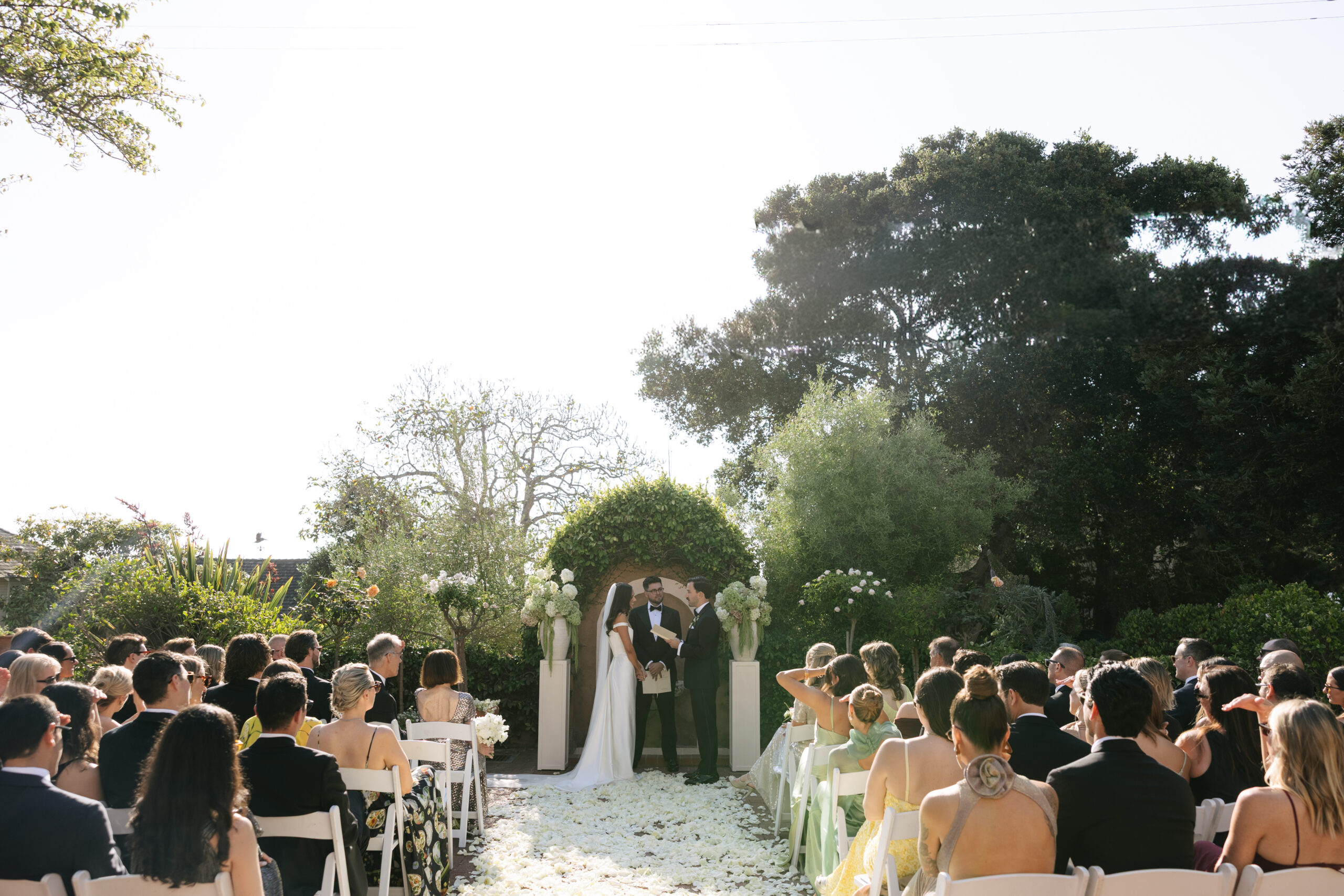 A wedding ceremony in a courtyard at La Playa Hotel in Carmel CA