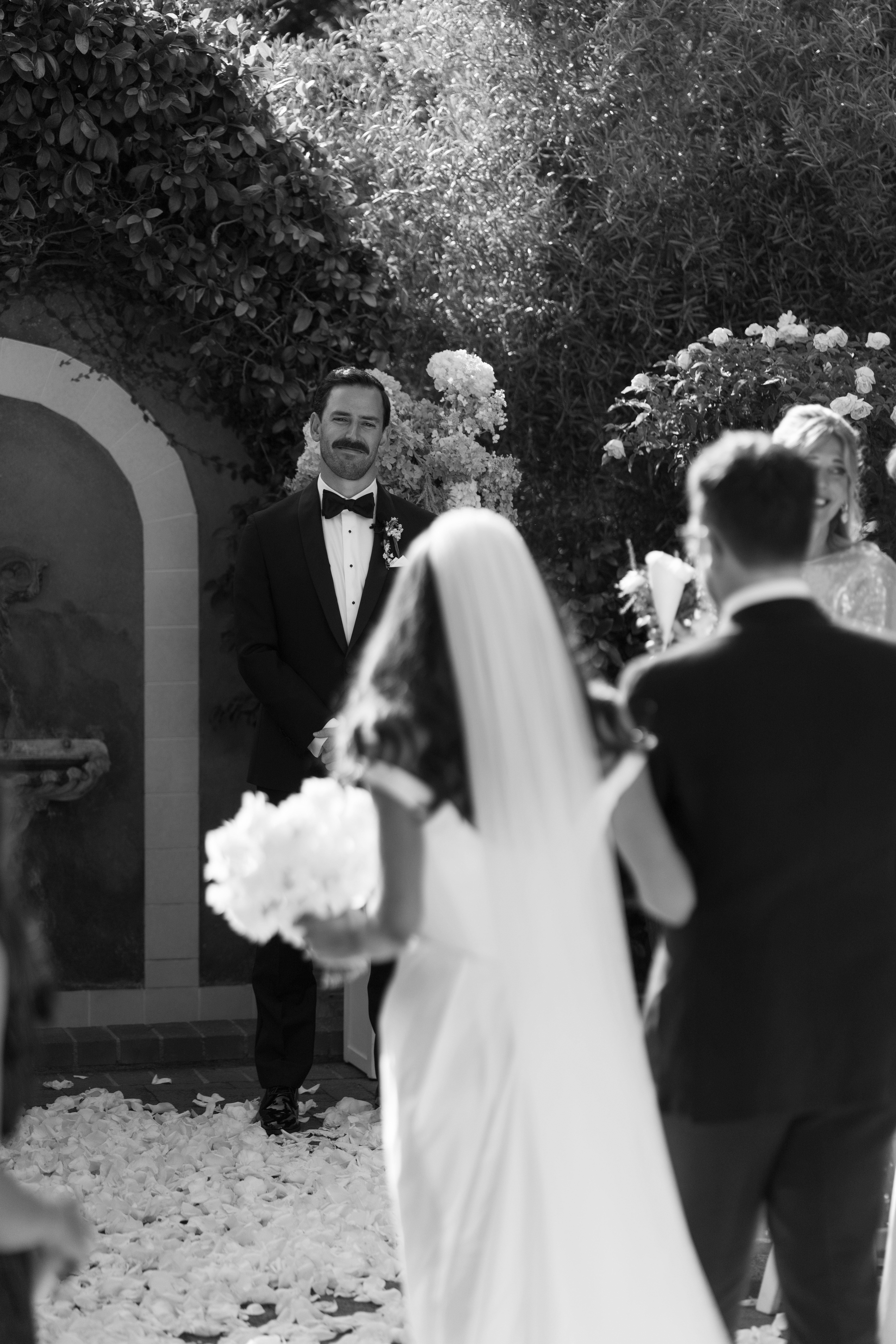 Groom lovingly watching bride walk down the aisle