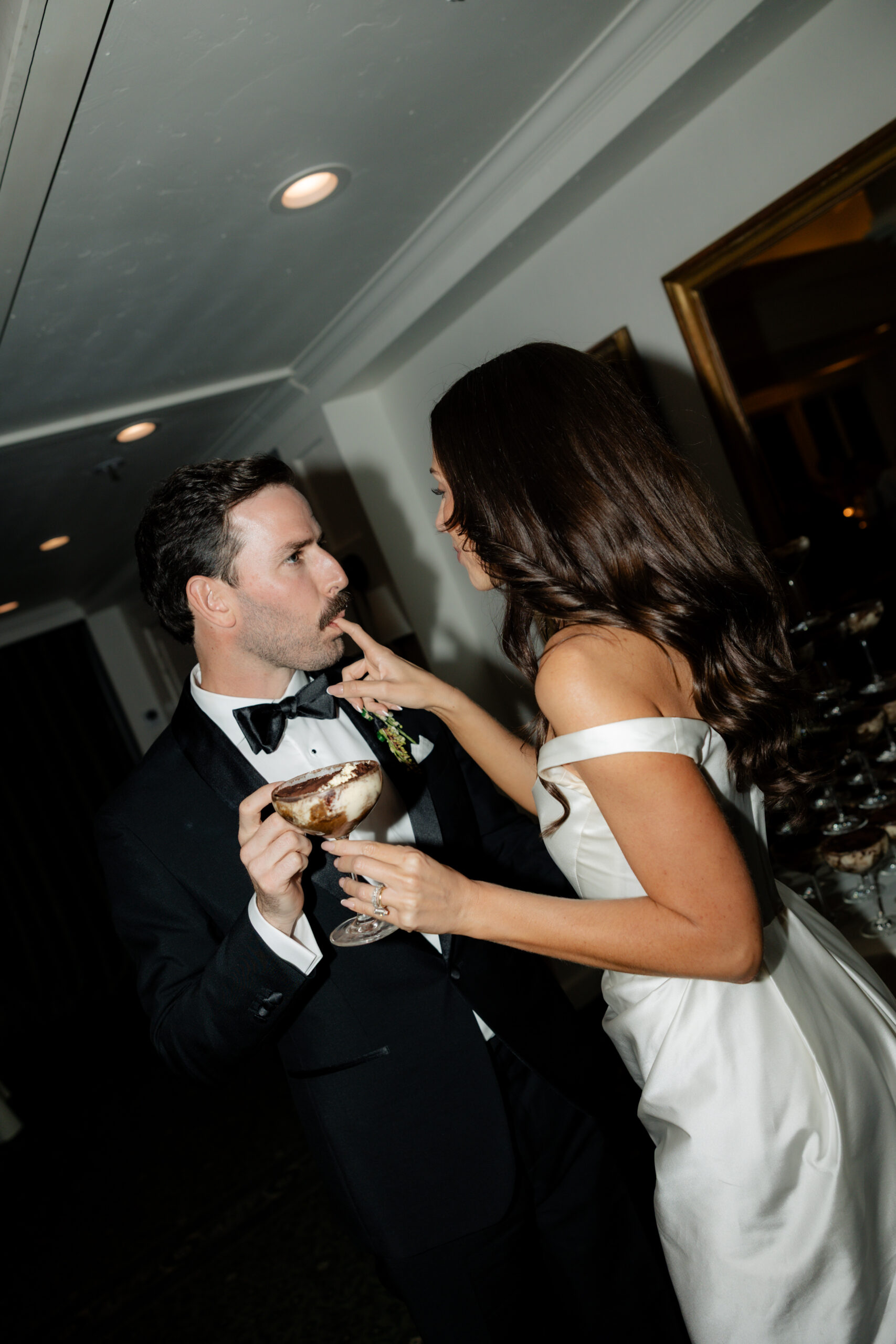 Bride and groom eating tiramisu wedding cake in a direct flash photo