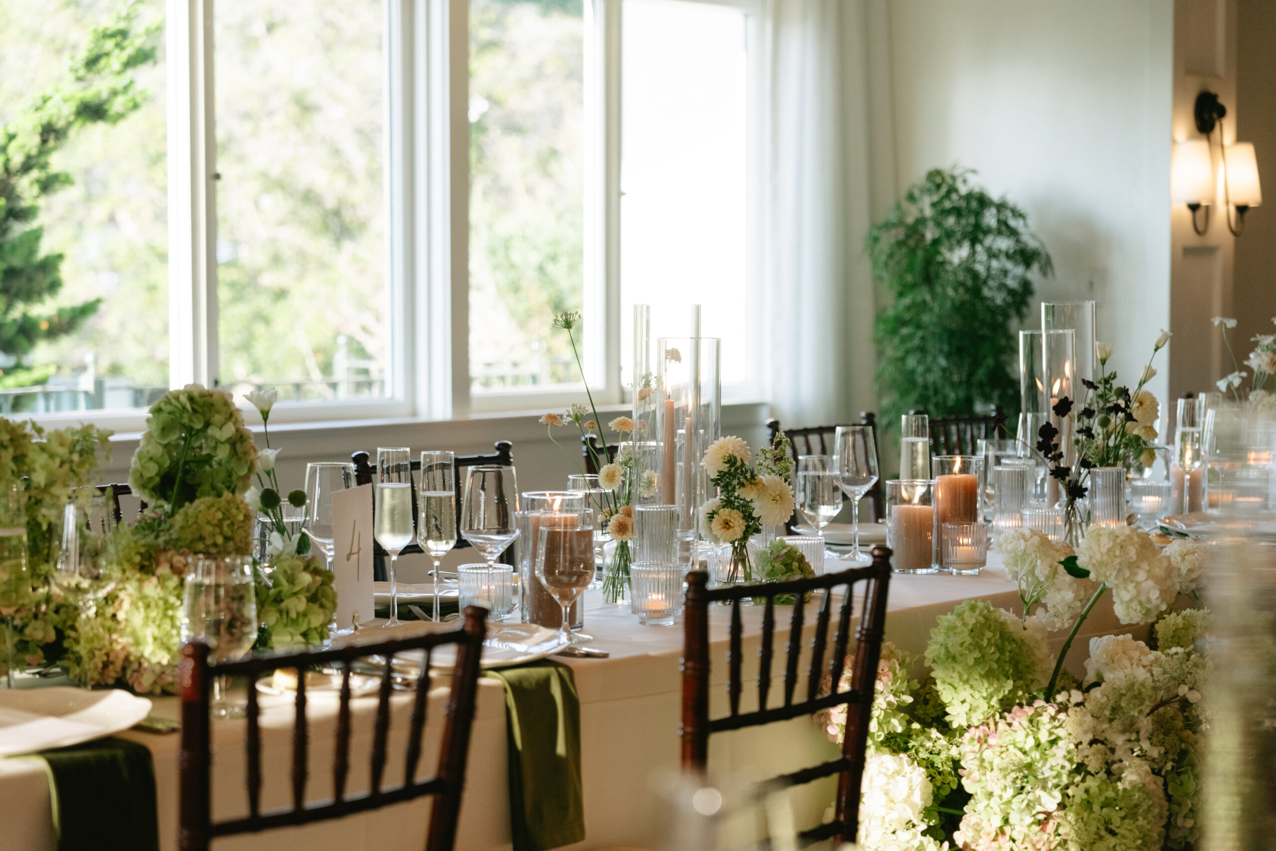 Indoor wedding reception setup with flowers and candles lining the tables