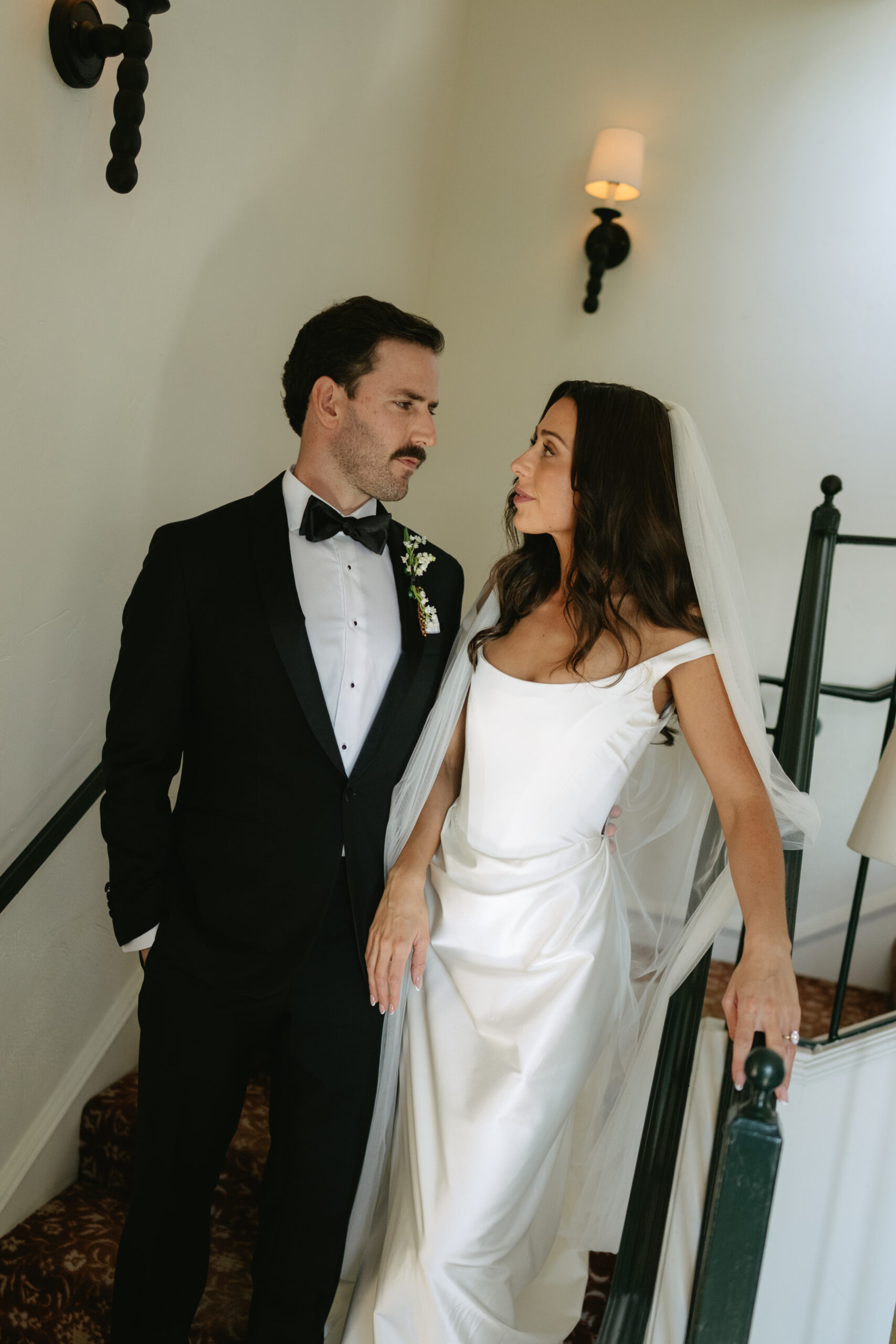 Bride and groom looking at each other while walking down steps