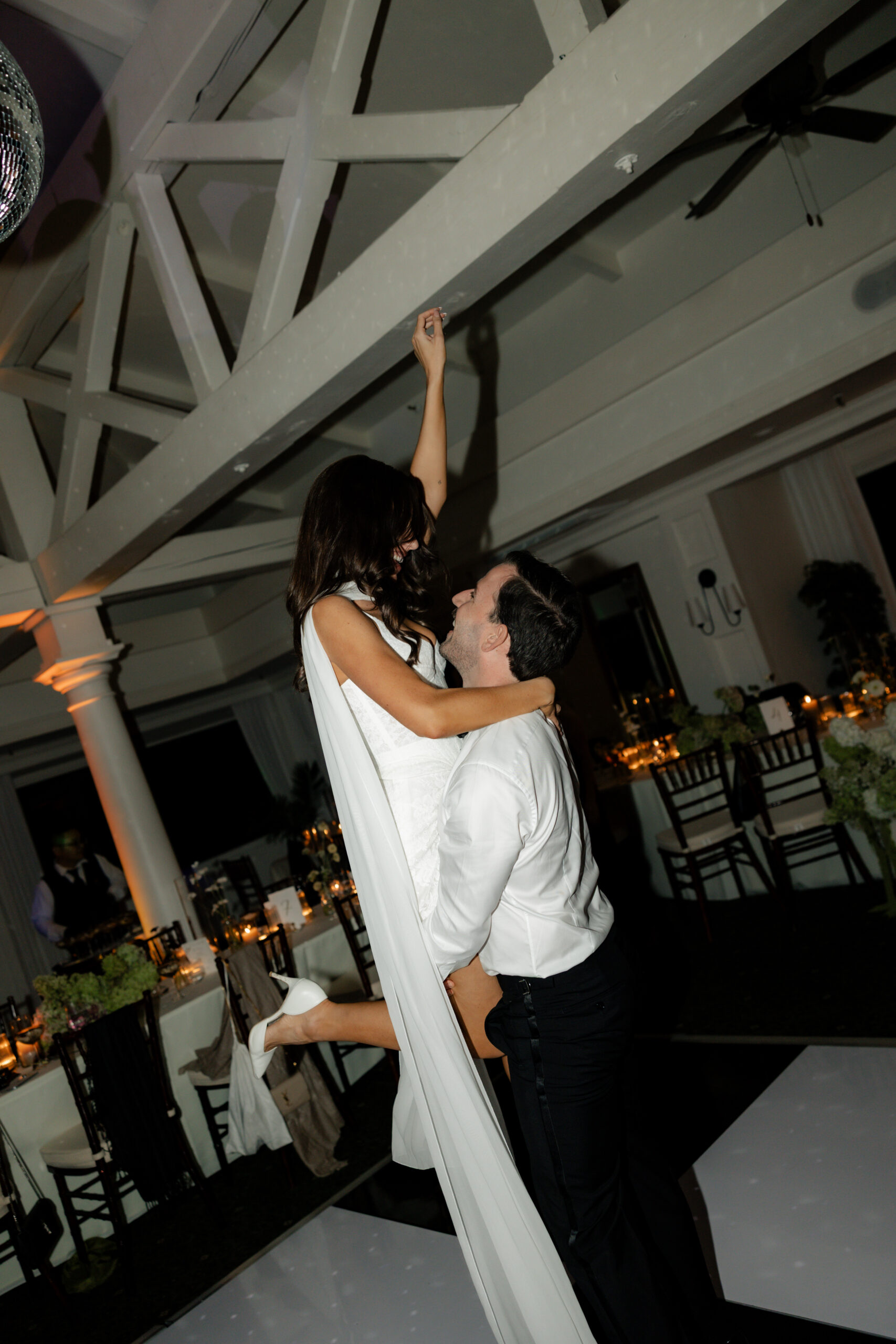 Groom lifting up bride during a dance at their wedding reception