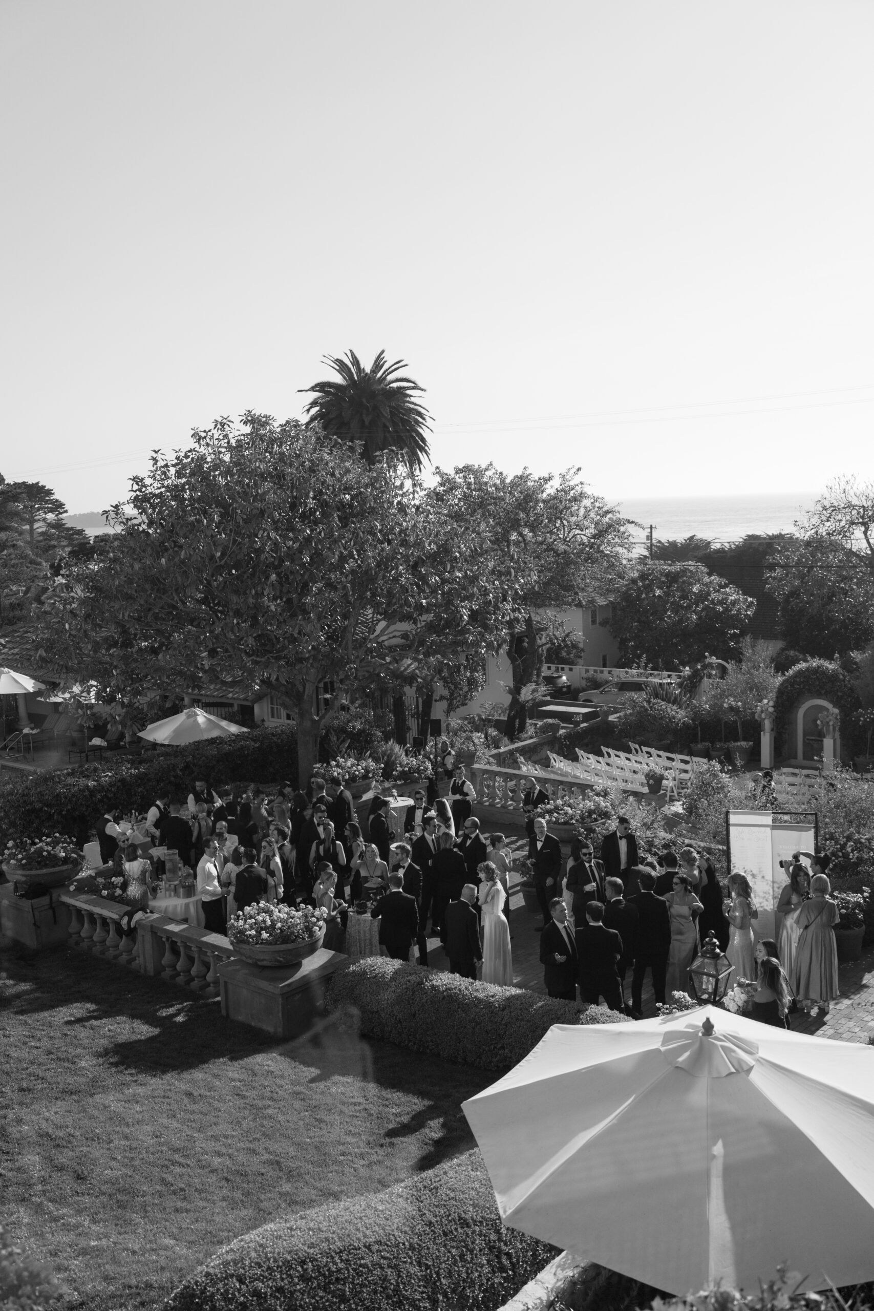 Black and white photo of wedding guests enjoying cocktail hour at La Playa Hotel in Carmel CA