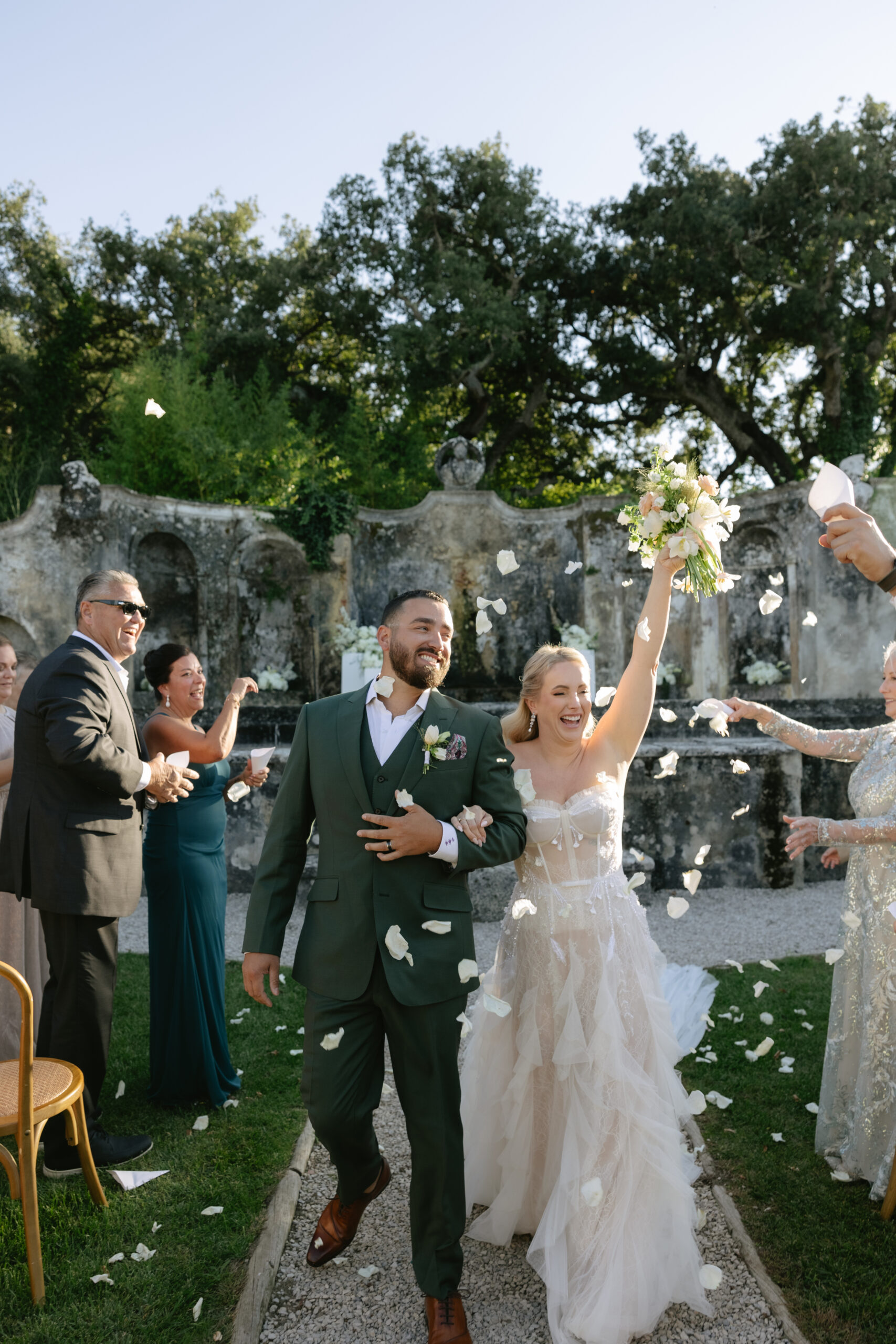 Bride and groom celebrating after their wedding ceremony while confetti is being thrown