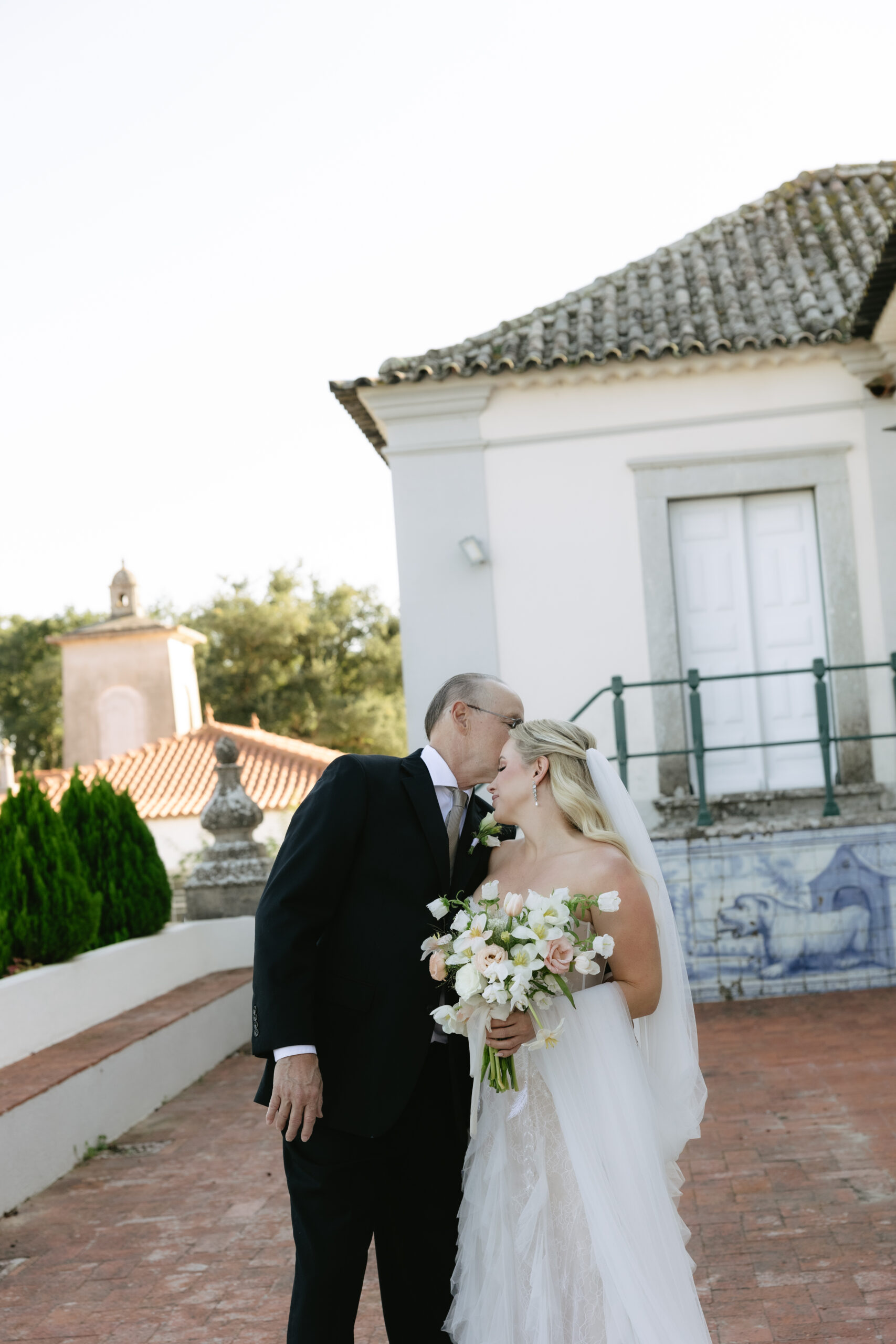 Bride's dad kissing her on the head during first look photos