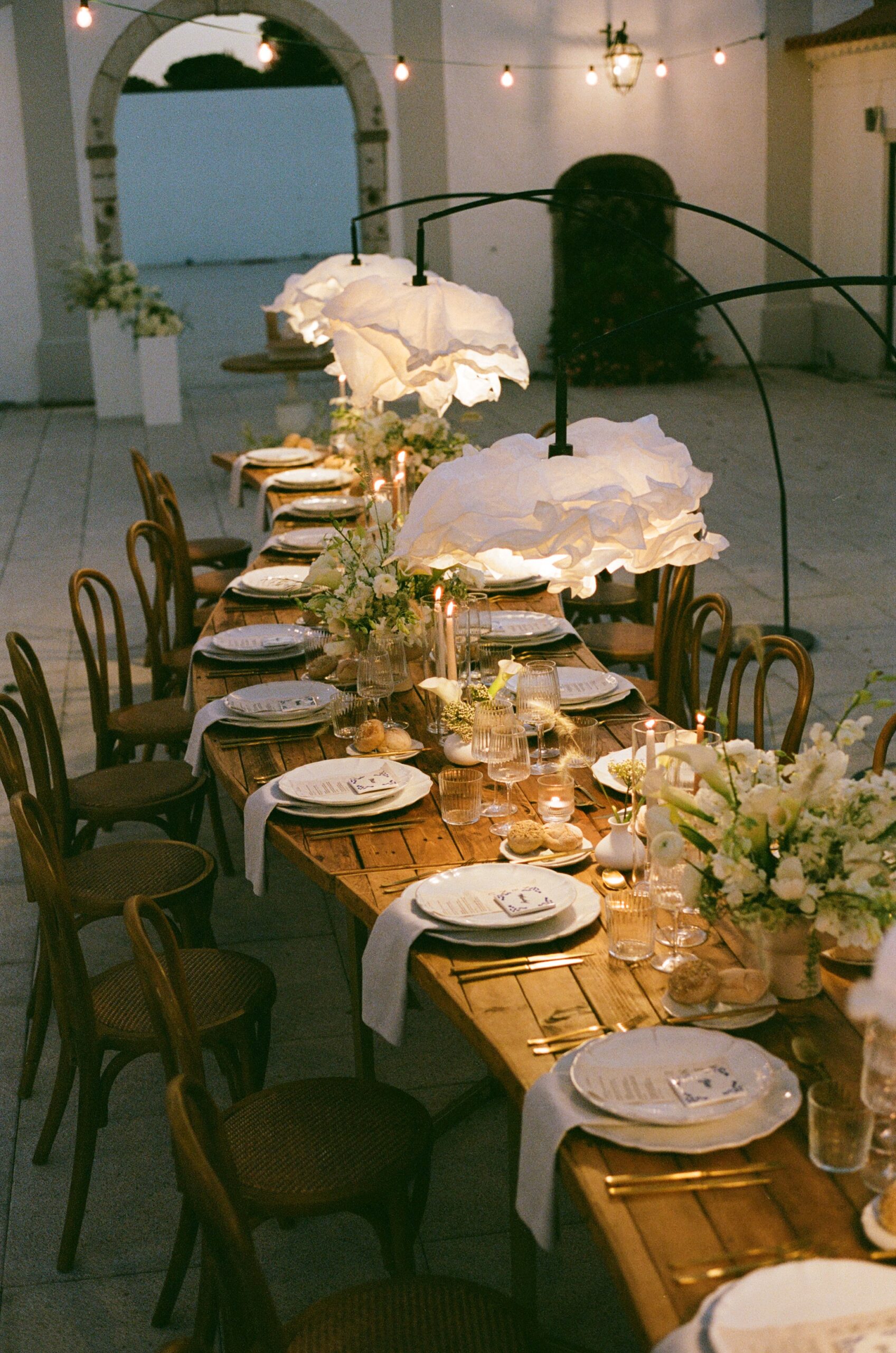 Wedding reception table setup with curved tables and dim lighting