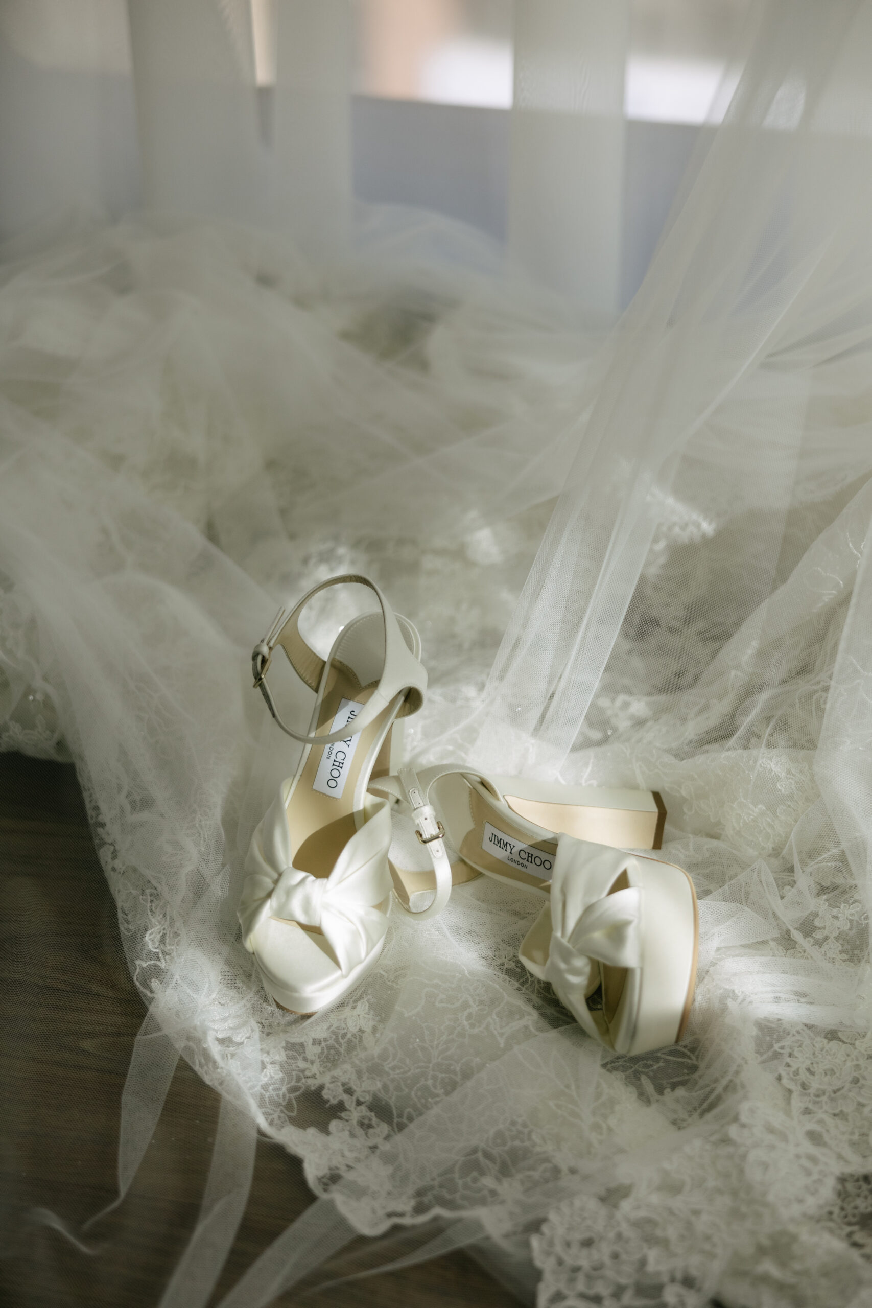 Wedding shoes laying on a lace wedding veil for wedding detail photos