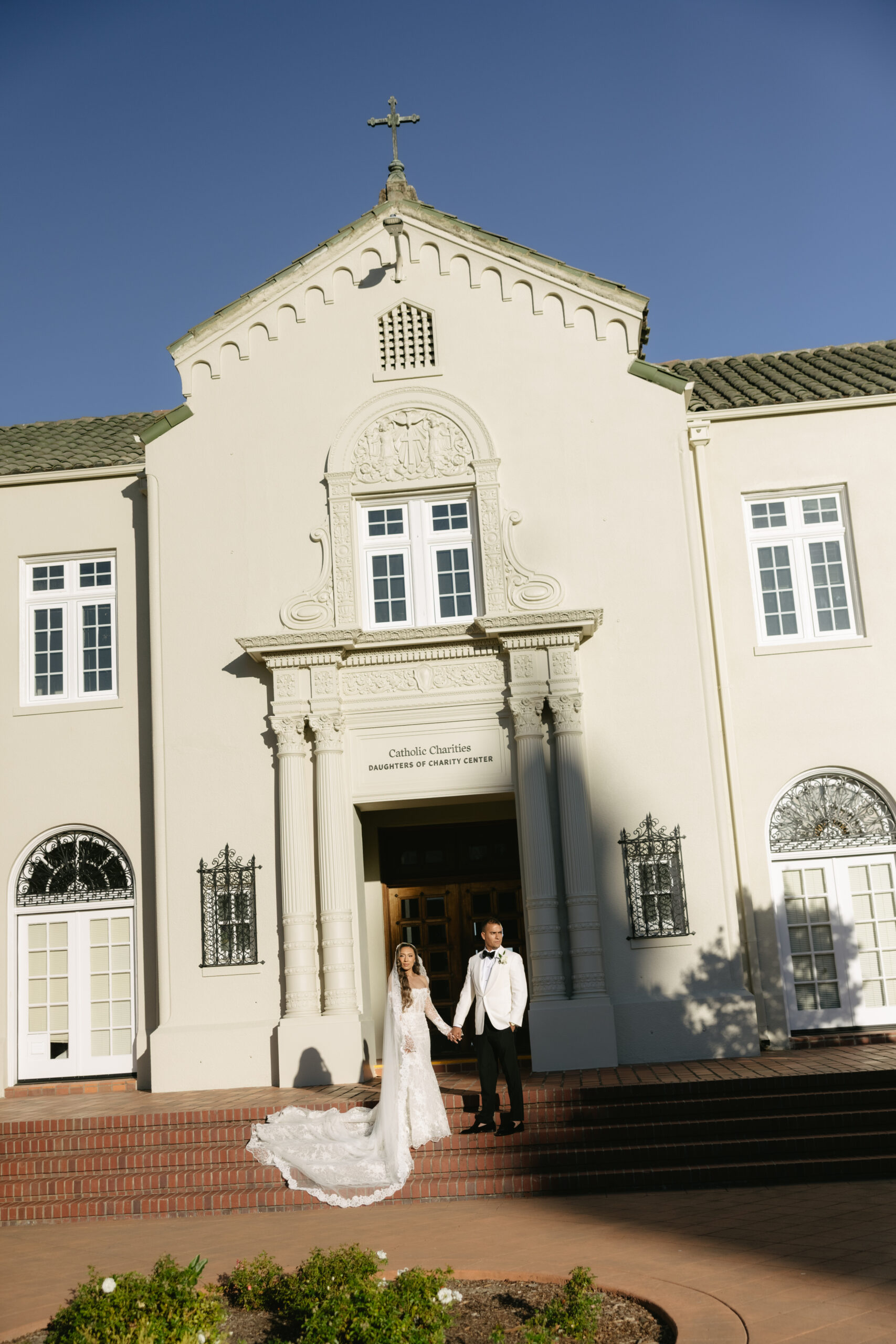 A bride and groom outside of a Catholic church where they held their Catholic wedding