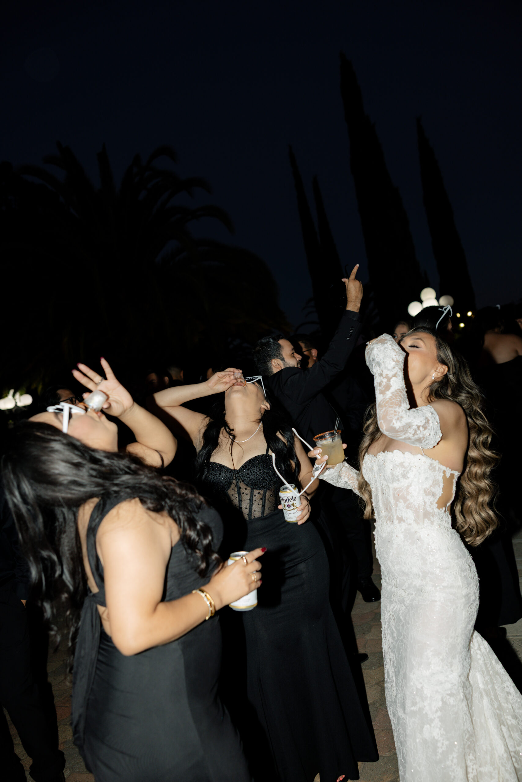 A bride and two bridesmaids taking shots at a wedding reception