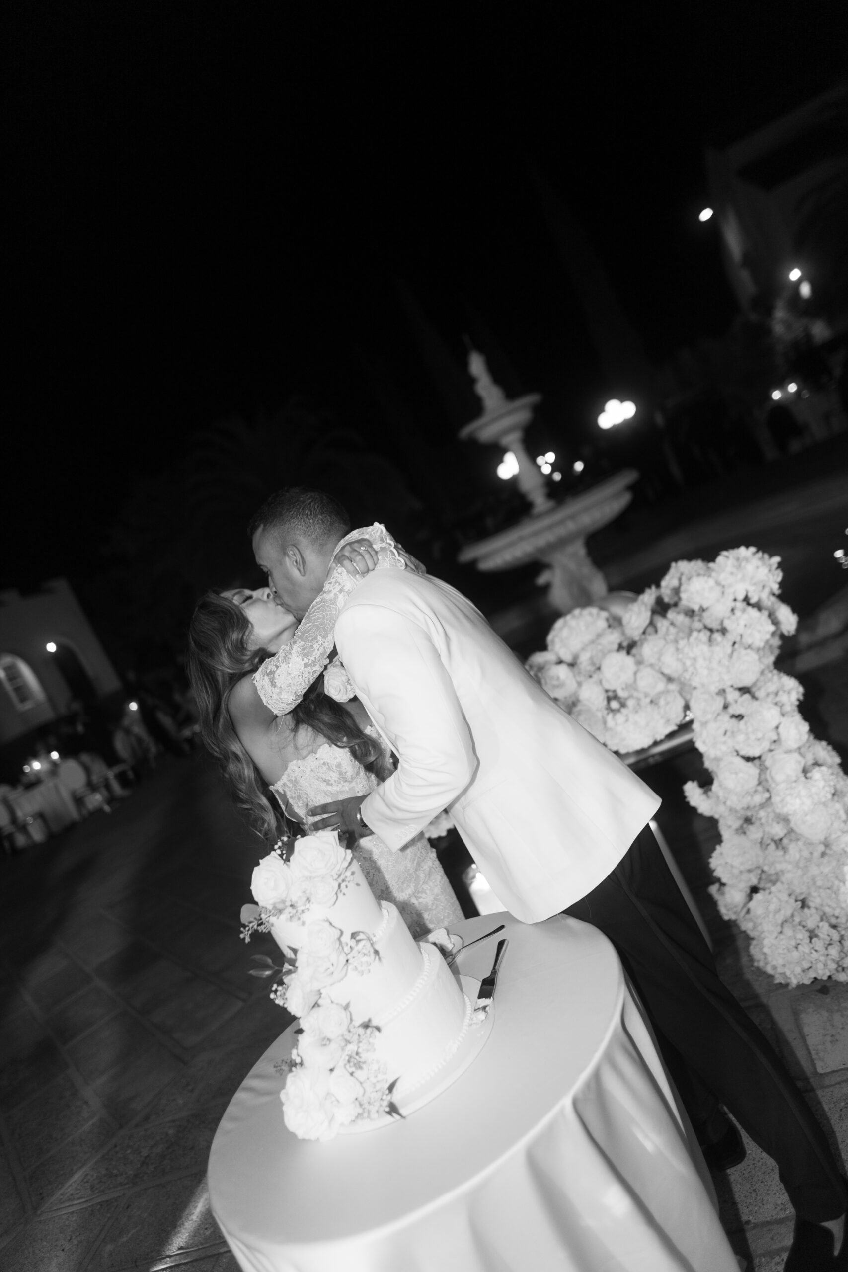 A bride and groom kissing after their wedding cake cutting