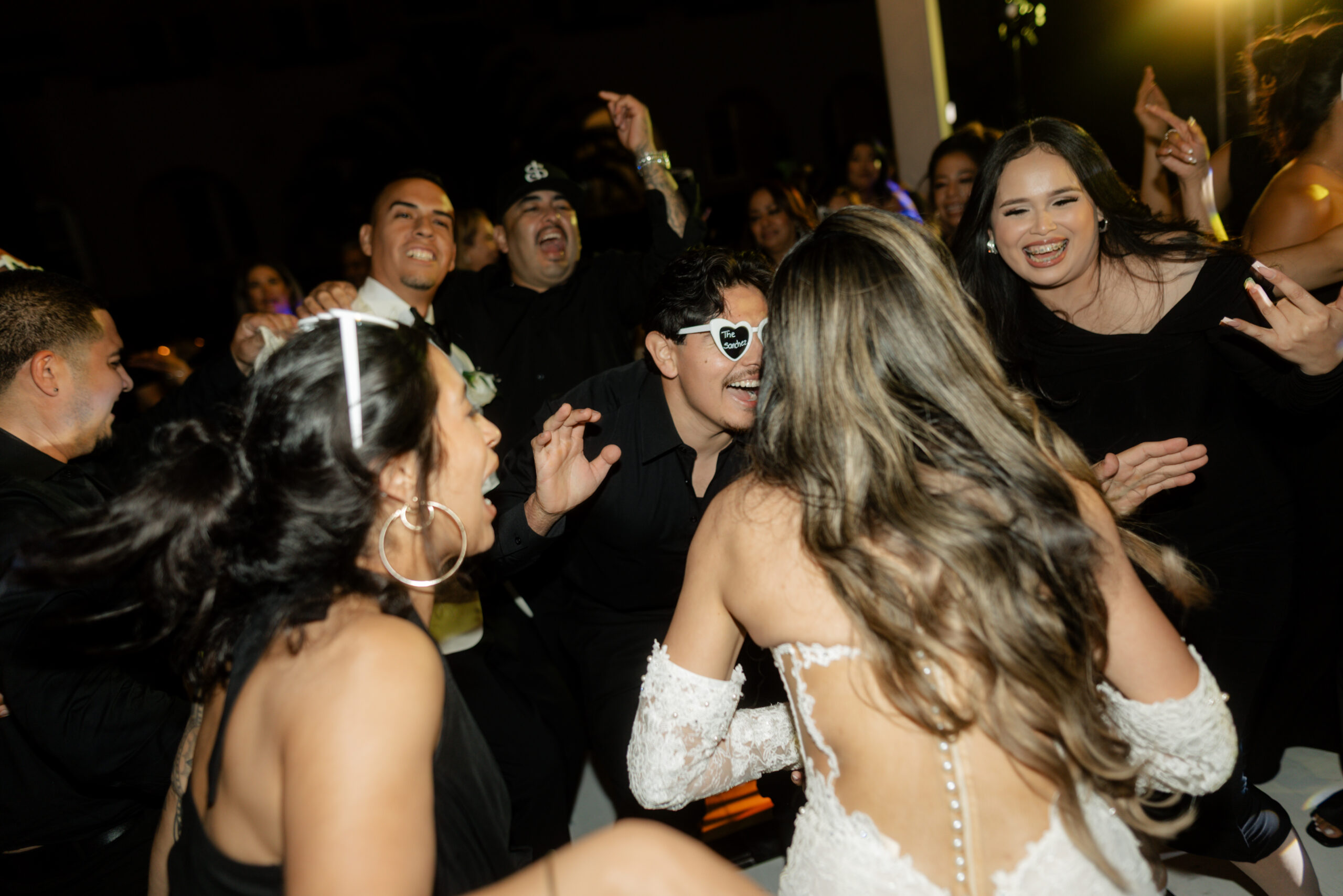 A candid wedding reception photo of a bride dancing with her friends