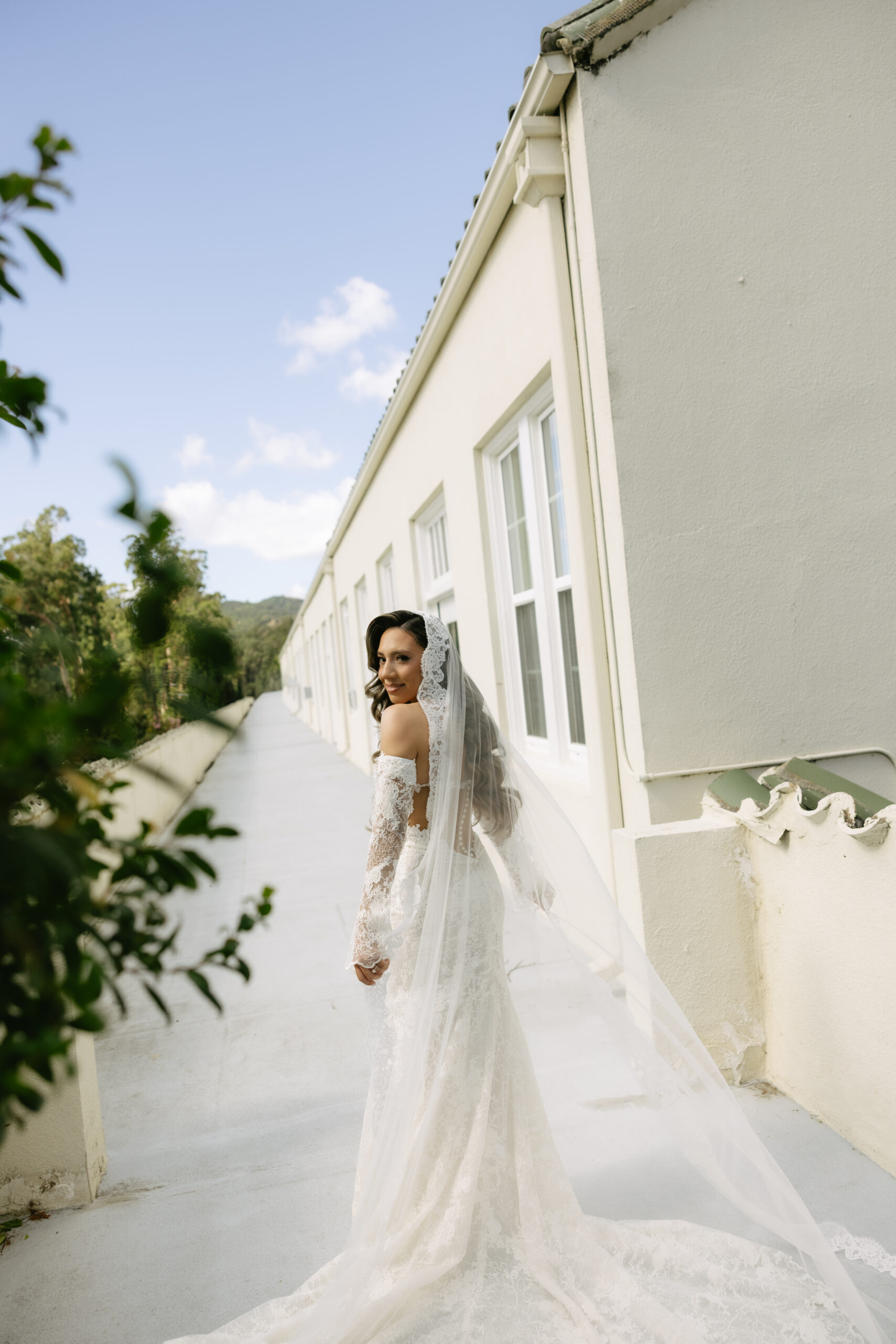 A bride turned away from the camera, showing her lace wedding veil