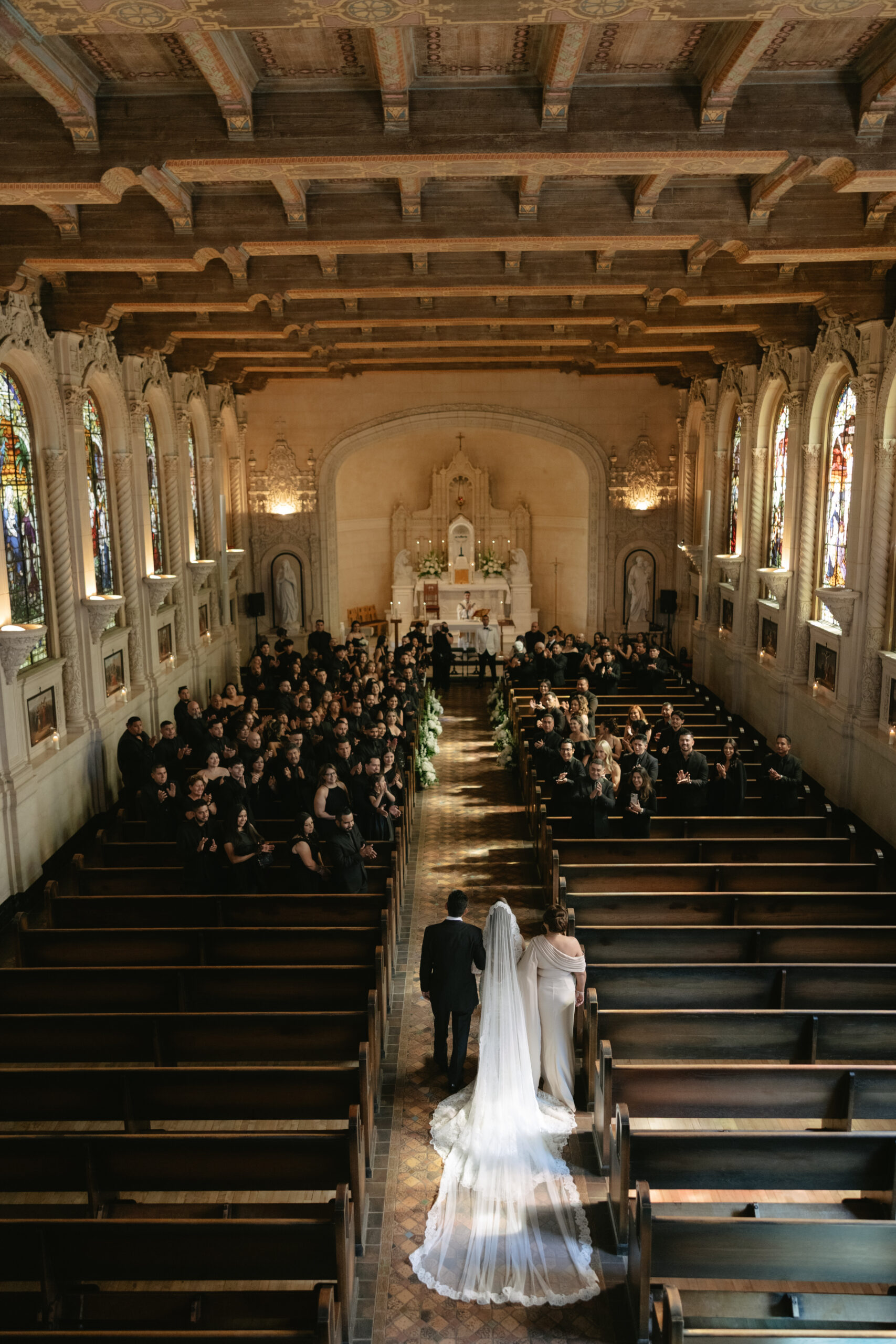 A bride's parents walking her down the aisle in a Church wedding ceremony