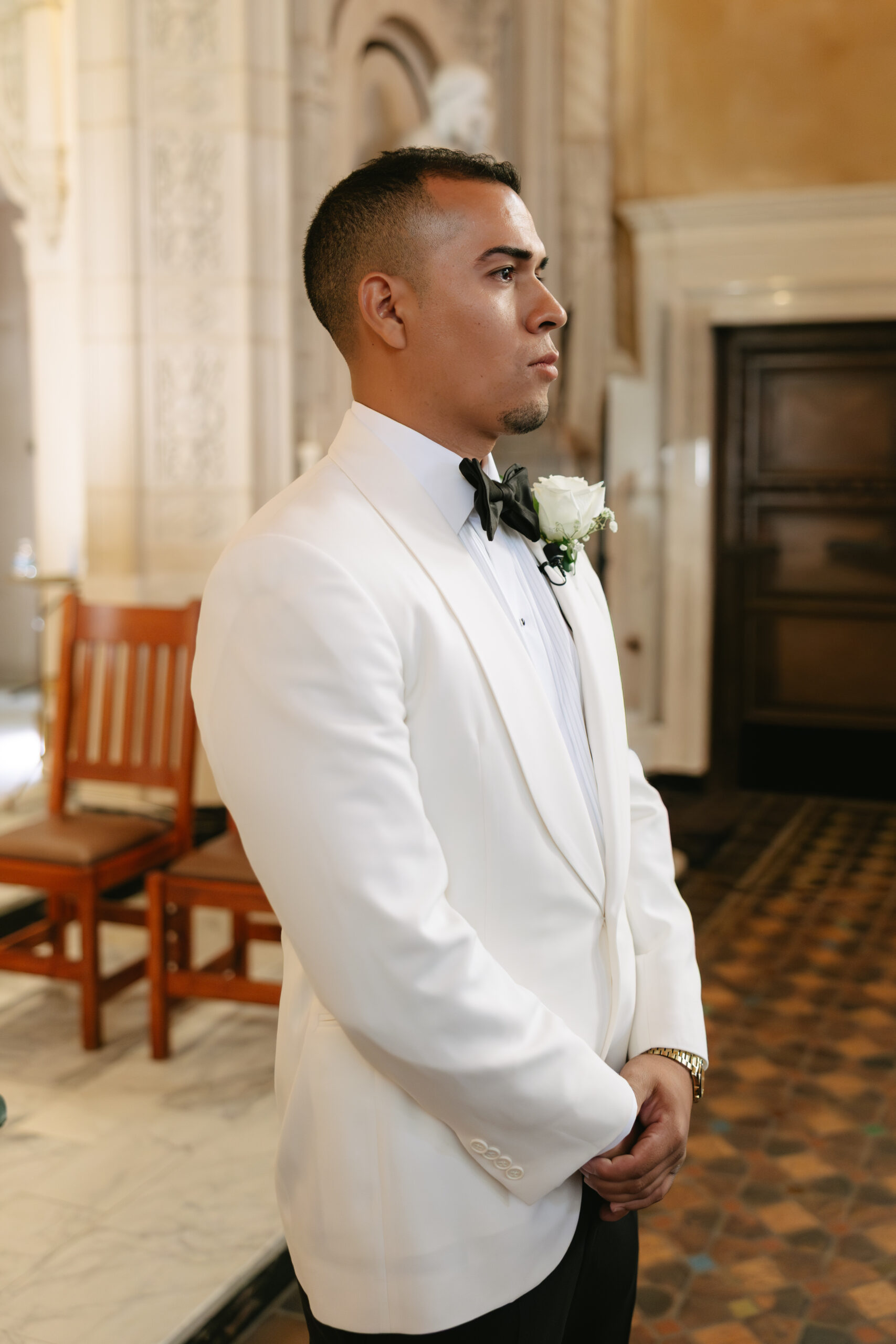 A groom watching his bride walk down the aisle