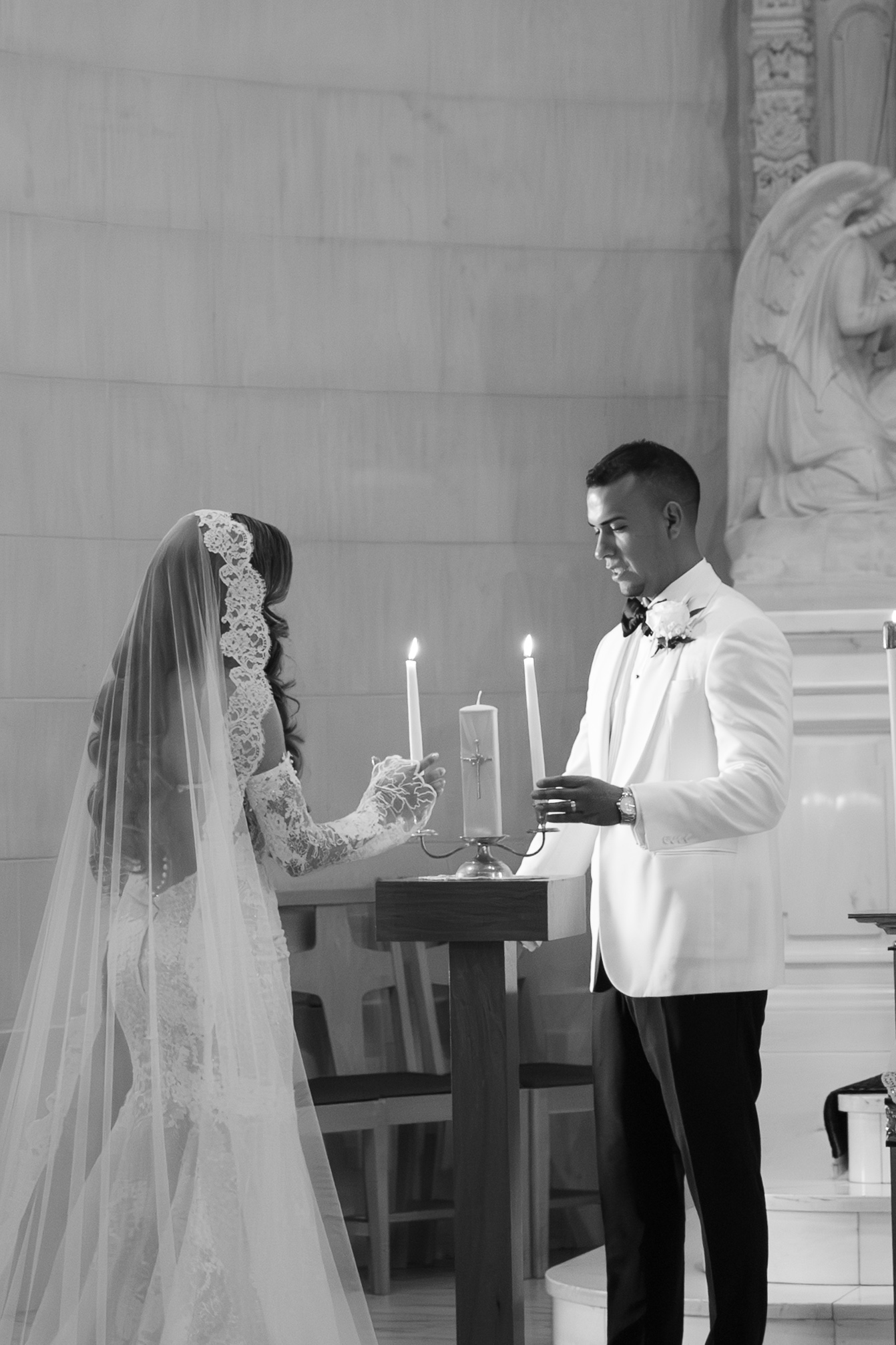 A couple lighting unity candles during their wedding ceremony, a tradition in Catholic weddings