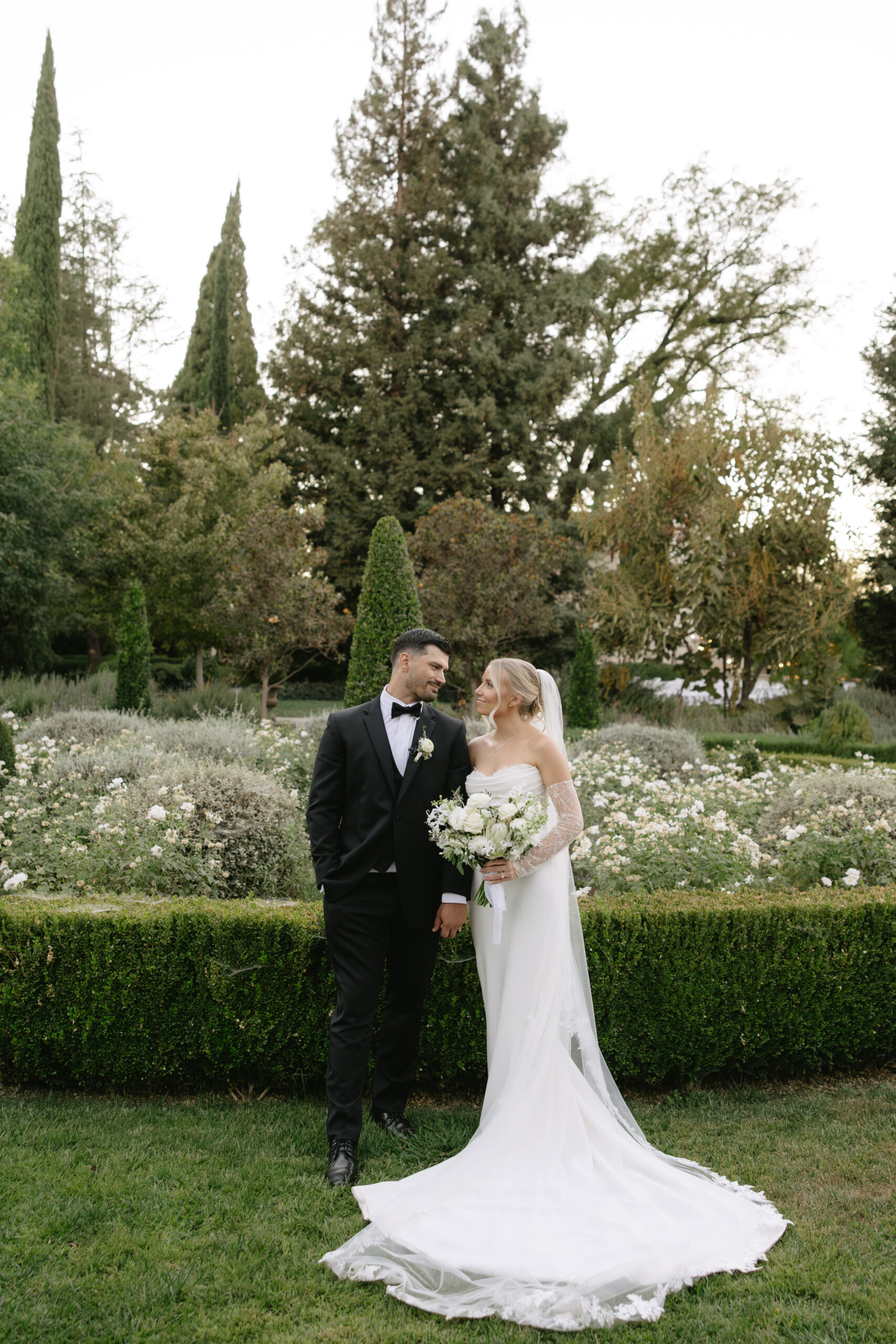 A couple posing for portraits in the gardens at Park Winters