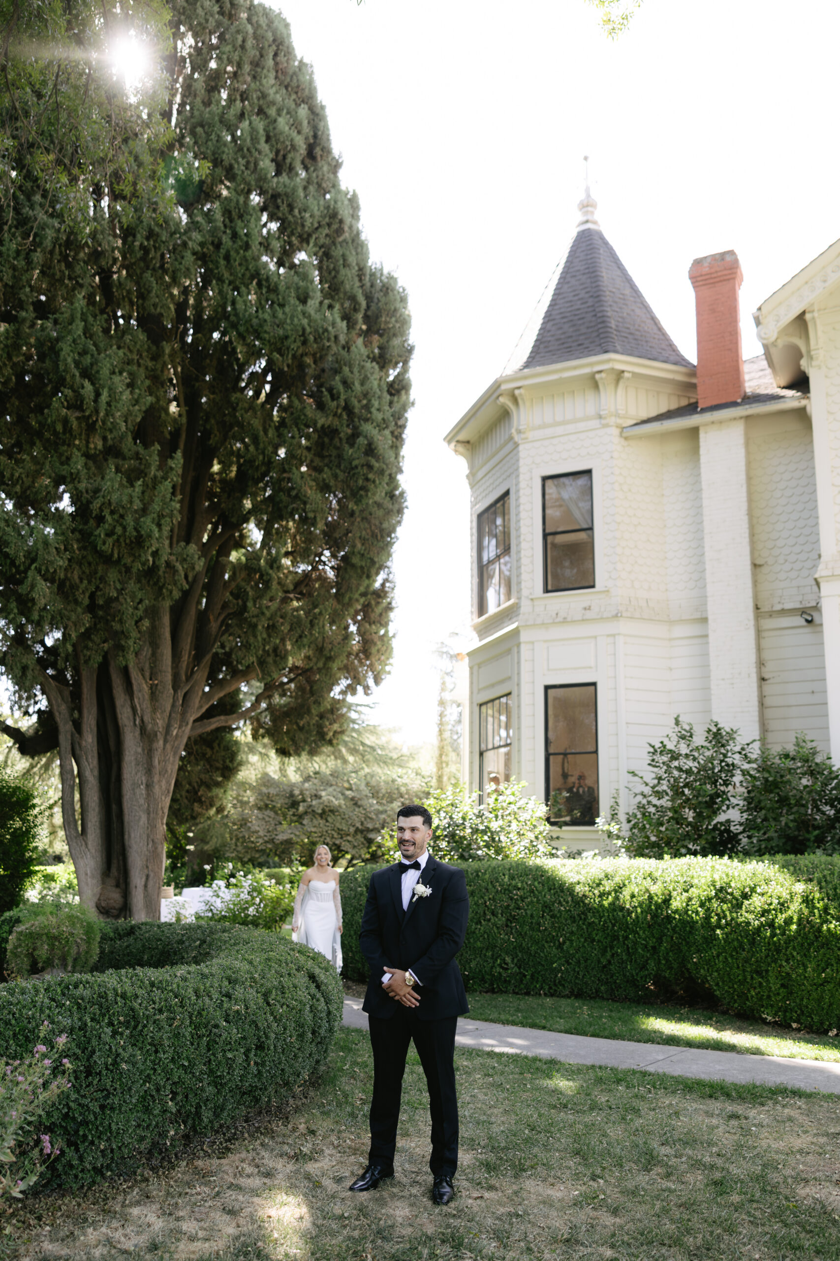 A bride walking to do a first look with her husband in front of a historic home at Park Winters California wedding venue