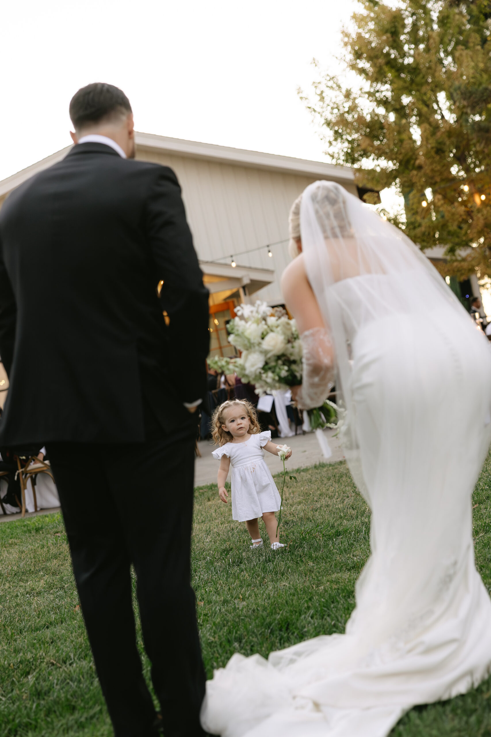 A wedding couple talking to a little girl