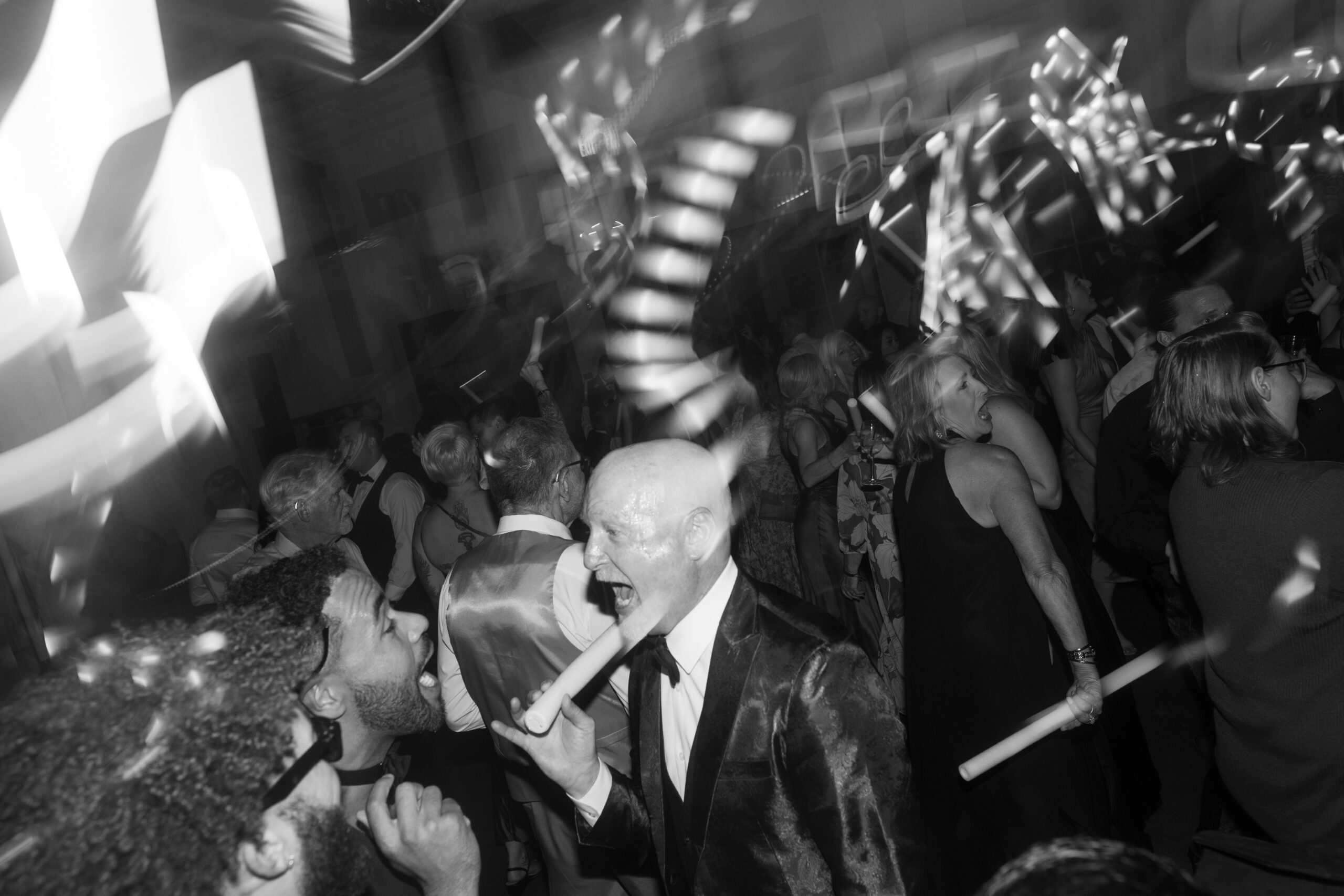 A blurry candid photo of guests dancing at a wedding reception