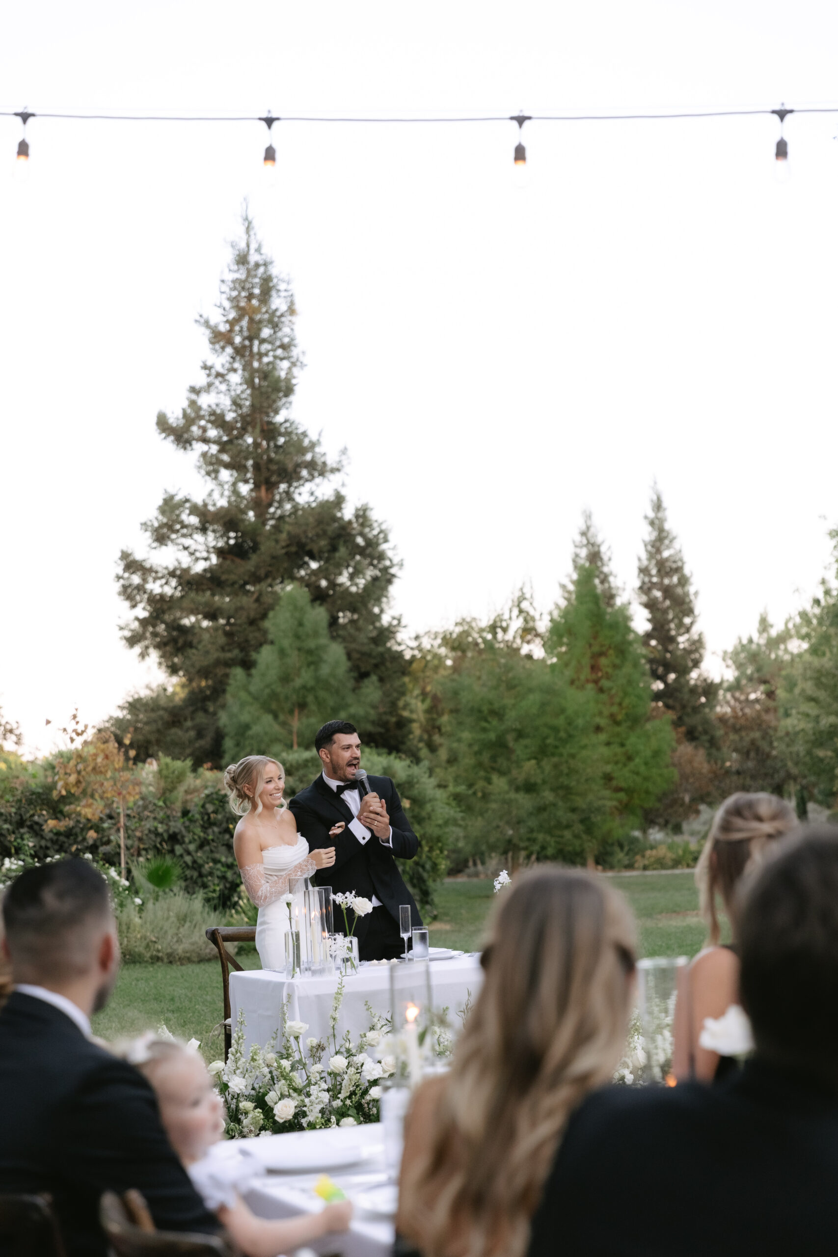 A candid photo of a bride and groom laughing during their wedding reception, captured by a California wedding photographer