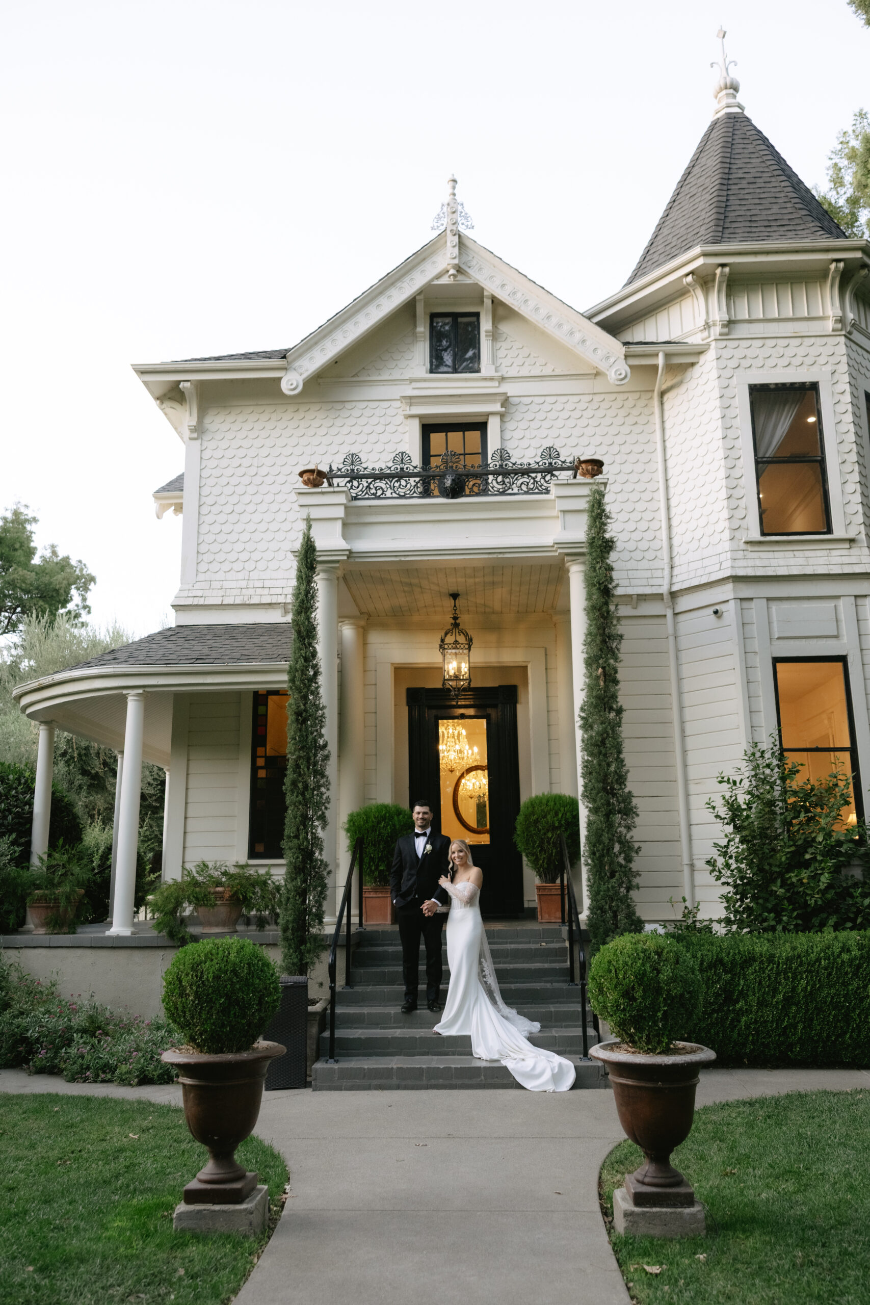 A bride and groom on the steps of their california wedding venue, park winters