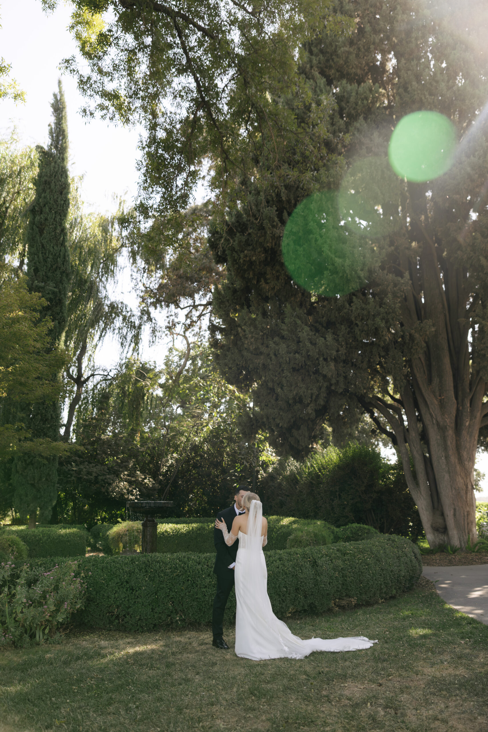 A bride and groom kissing in the gardens at park winters