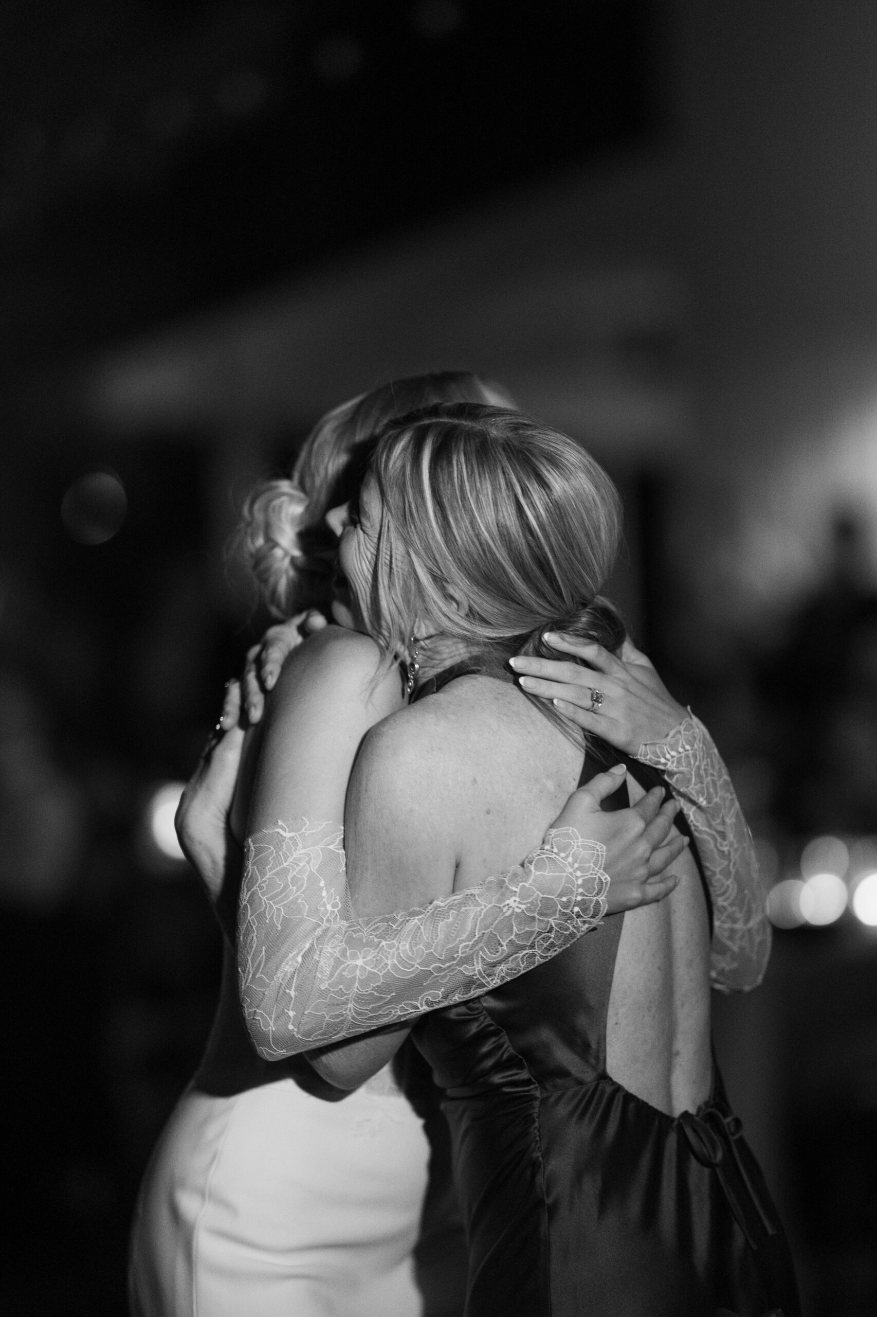 A bride and her mother hugging during a dance at a park winters wedding reception