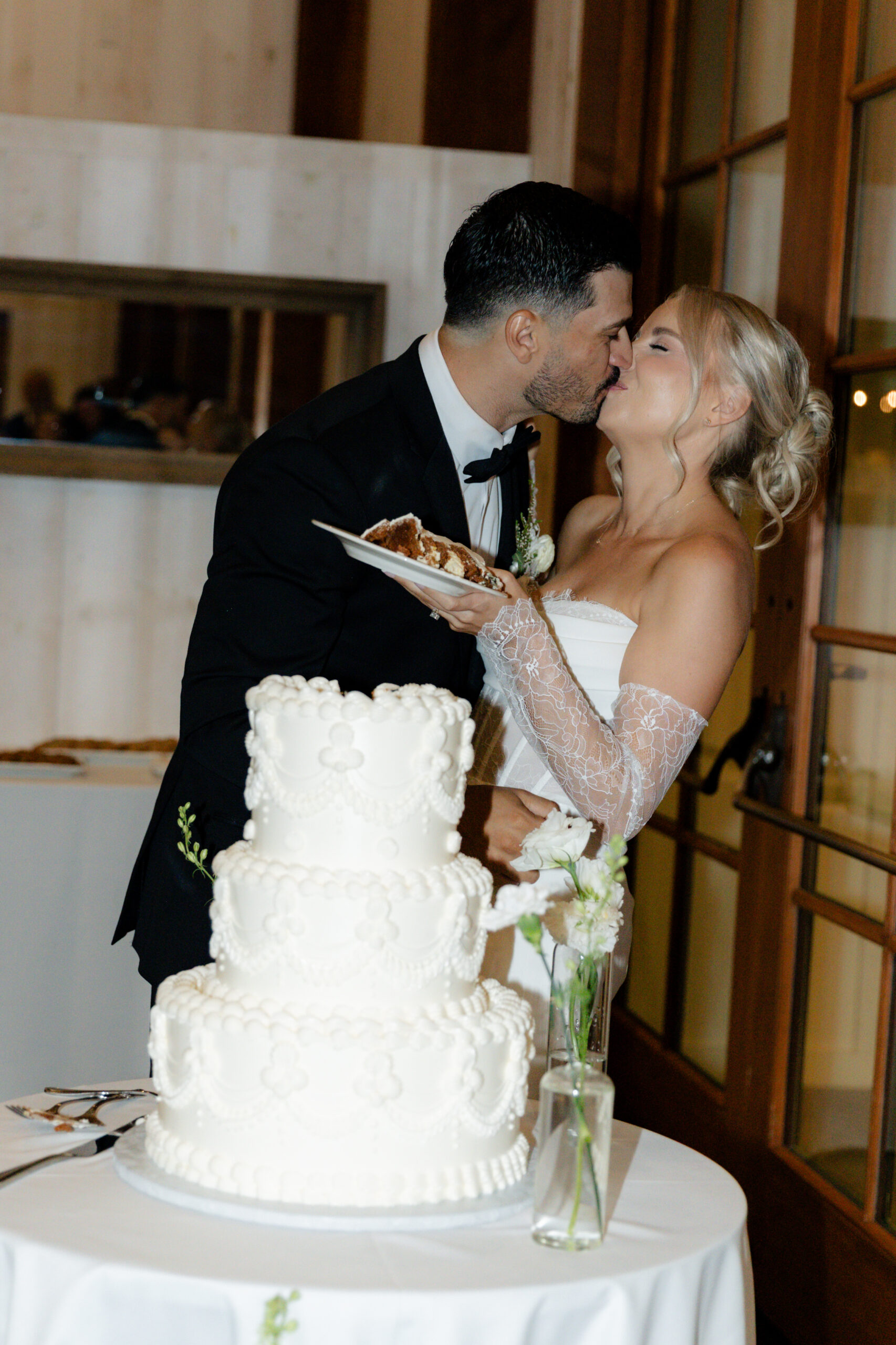 A couple kissing after their cake cutting